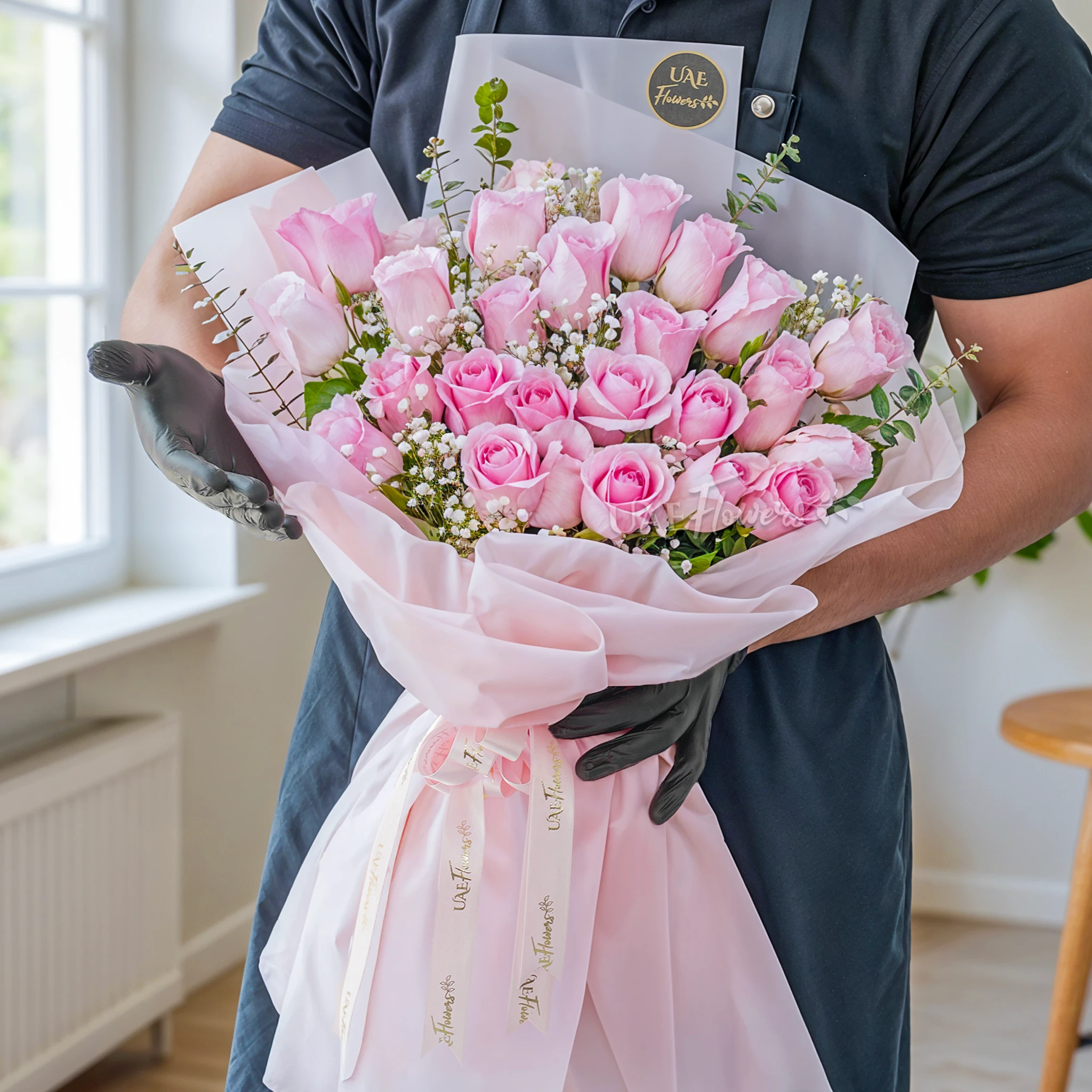 Bouquet of 24 pink roses with baby's breath & green fillers in a pink wrapping paper.
