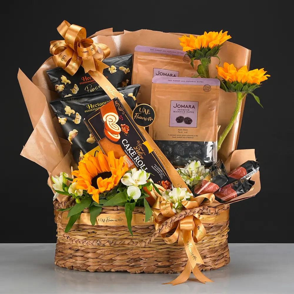 woven basket filled with sunflowers, alstroemerias, cake roll, popcorn, dates,