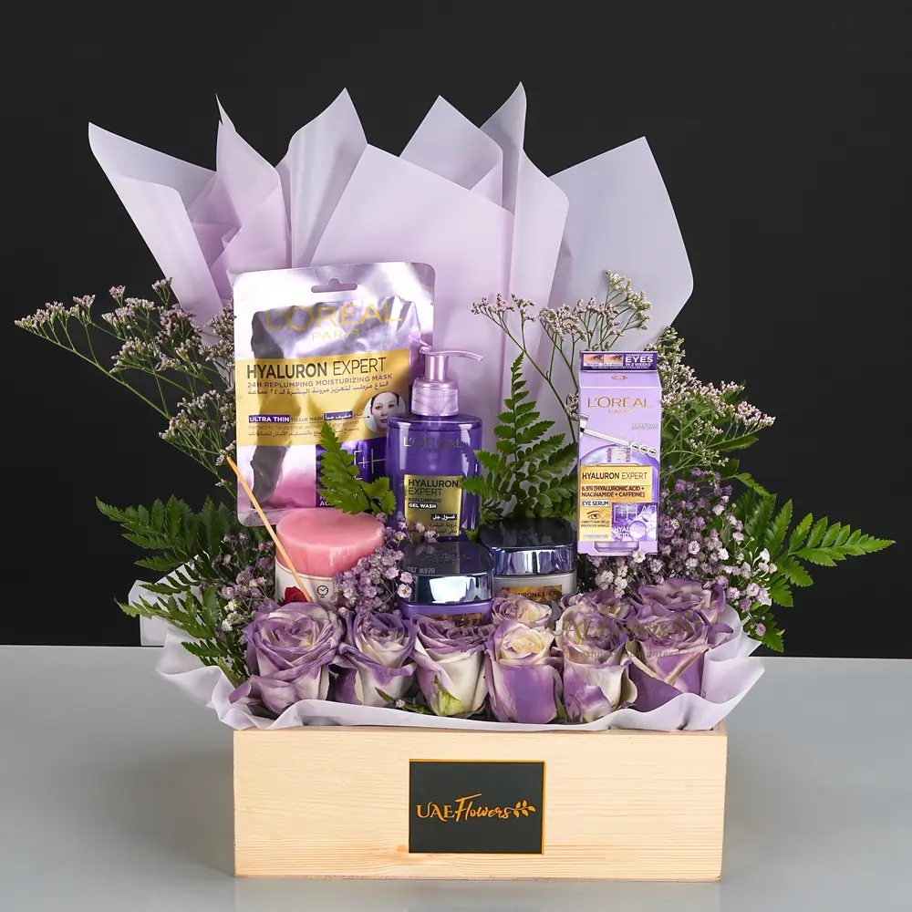 L'Oreal eye serum, day and night creams, face wash, a pink pillar candle, 10 white roses with purple spray