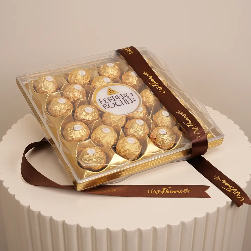 A bouquet of 6 red roses with green fillers in paper packing with a small teddy bear and 24 pcs ferrero rocher chocolate