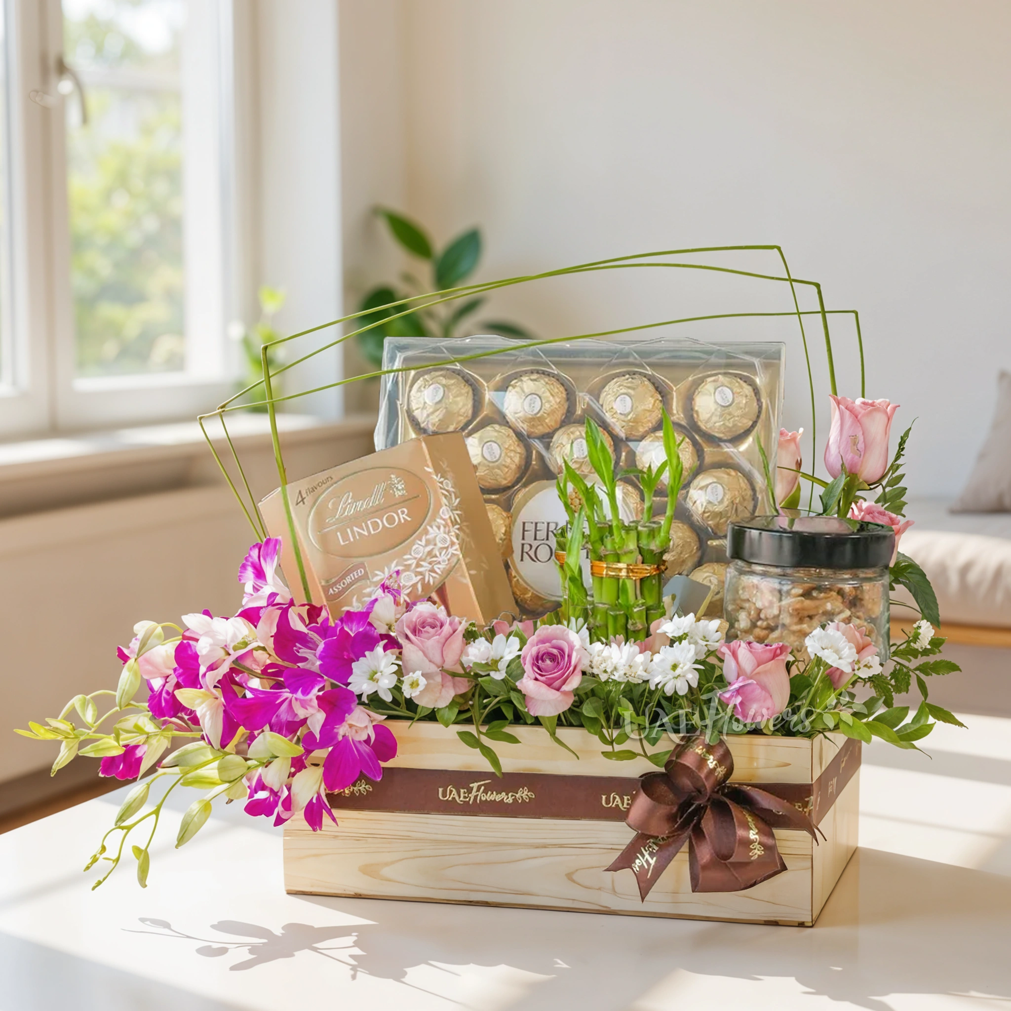 A wooden box arrangement of 10 pink roses, 5 purple orchids, white chrysanthemums, 250Gms of walnut in jar, 2 layer lucky bamboo, 24pcs of ferrero rocher chocolate and lindt lindor assorted chocolate box 200gms with green fillers.