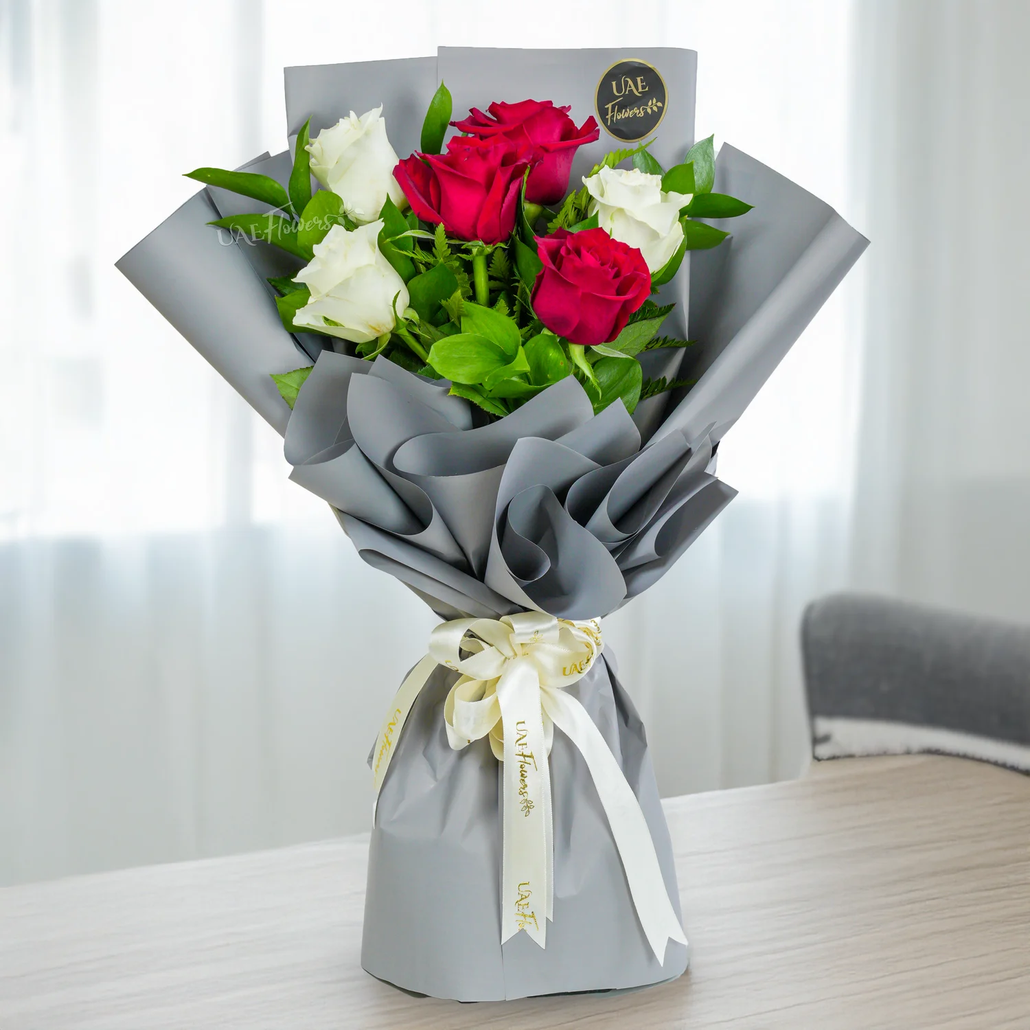 Bouquet of 6 red & white roses with green fillers in nice paper packing with ribbons, 1 kg butterscotch cake and a small white teddy bear.