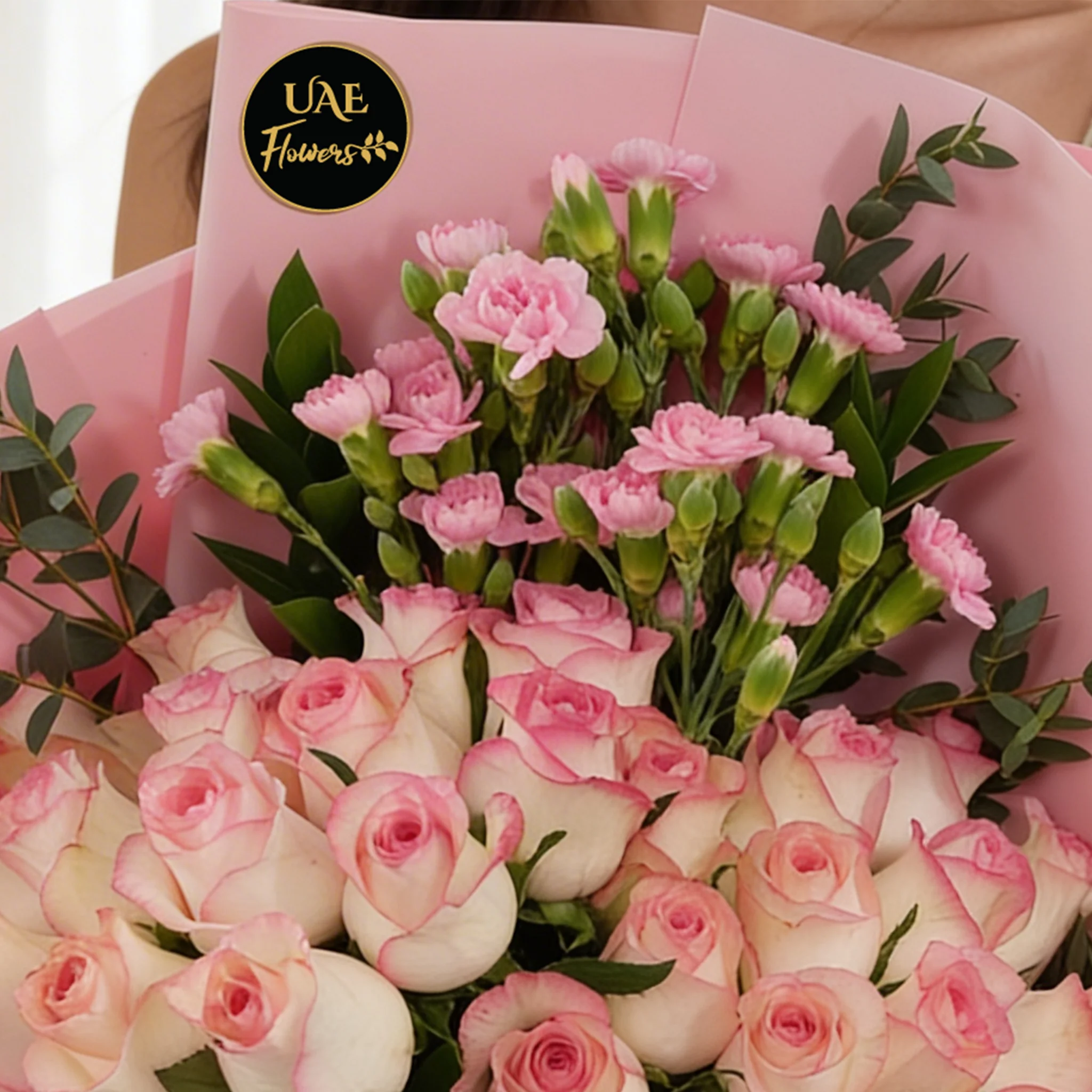 Bouquet of 30 pink roses and 5 pink spray carnations with green fillers in pink wrapping.