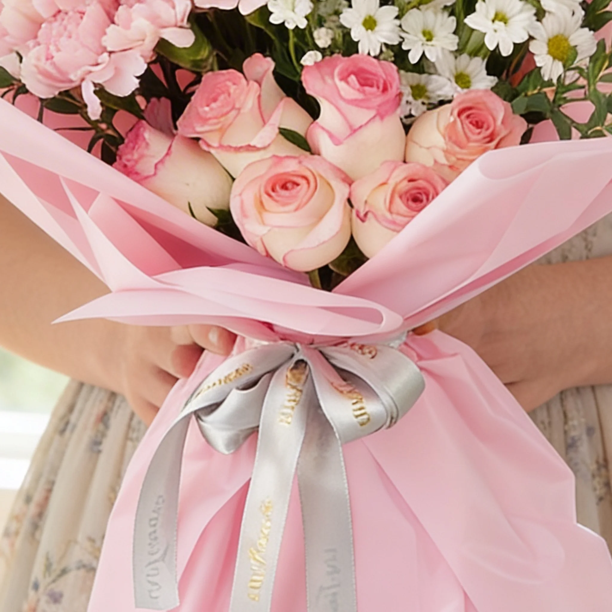 Bouquet of 8 pink carnations, 6 pink roses, 6 purple matthiola and 3 white chrysanthemums with green fillers in pink wrapping.