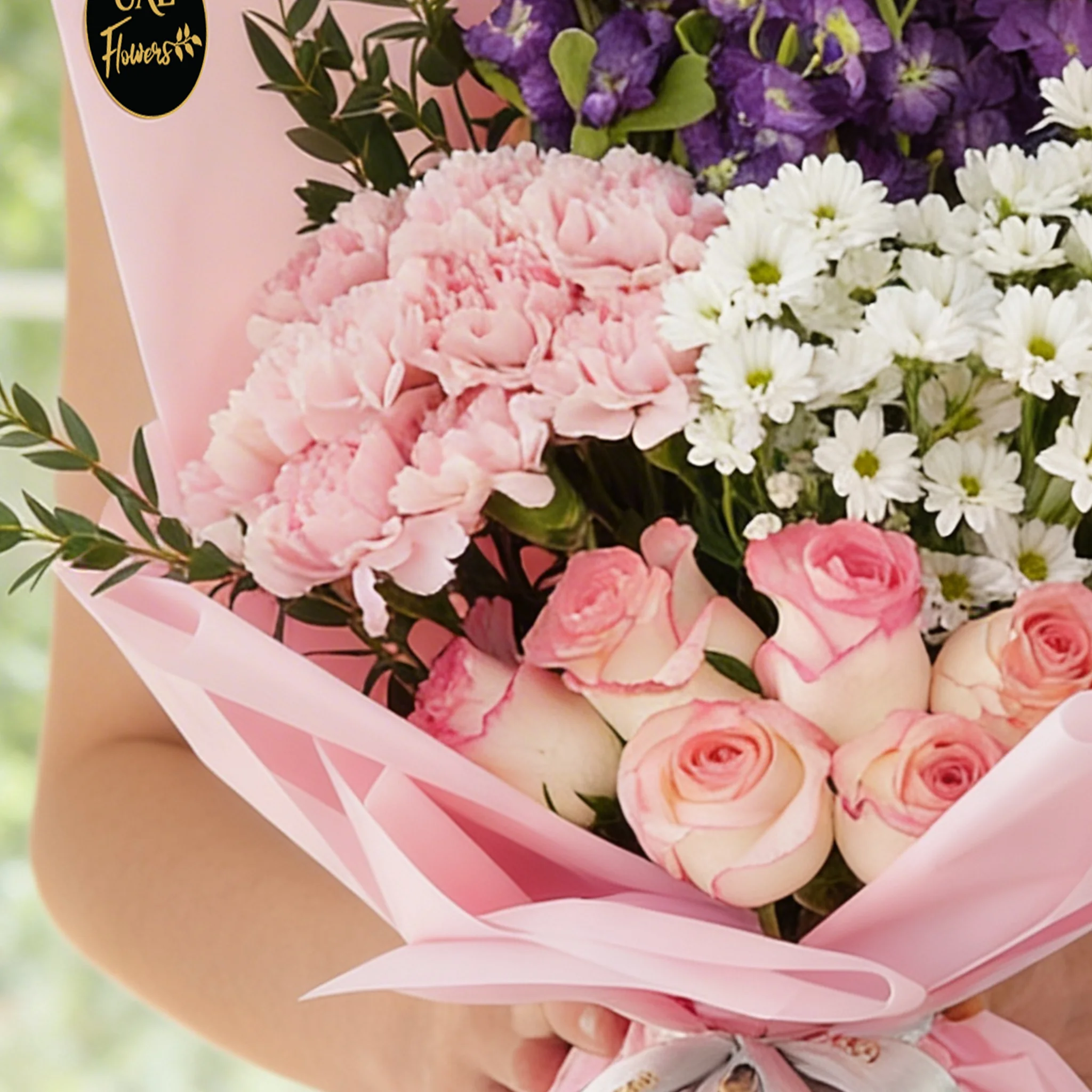 Bouquet of 8 pink carnations, 6 pink roses, 6 purple matthiola and 3 white chrysanthemums with green fillers in pink wrapping.