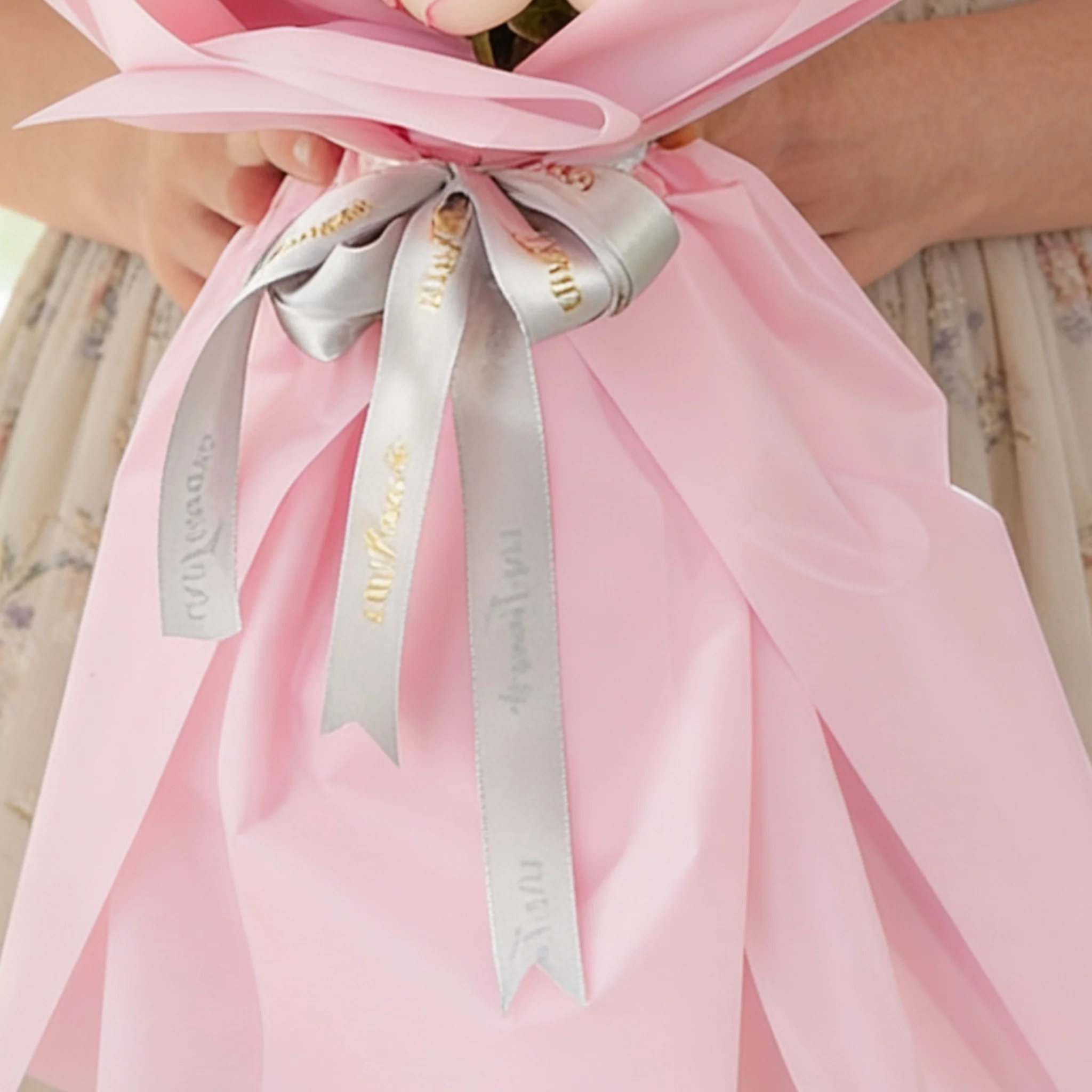 Bouquet of 8 pink carnations, 6 pink roses, 6 purple matthiola and 3 white chrysanthemums with green fillers in pink wrapping.