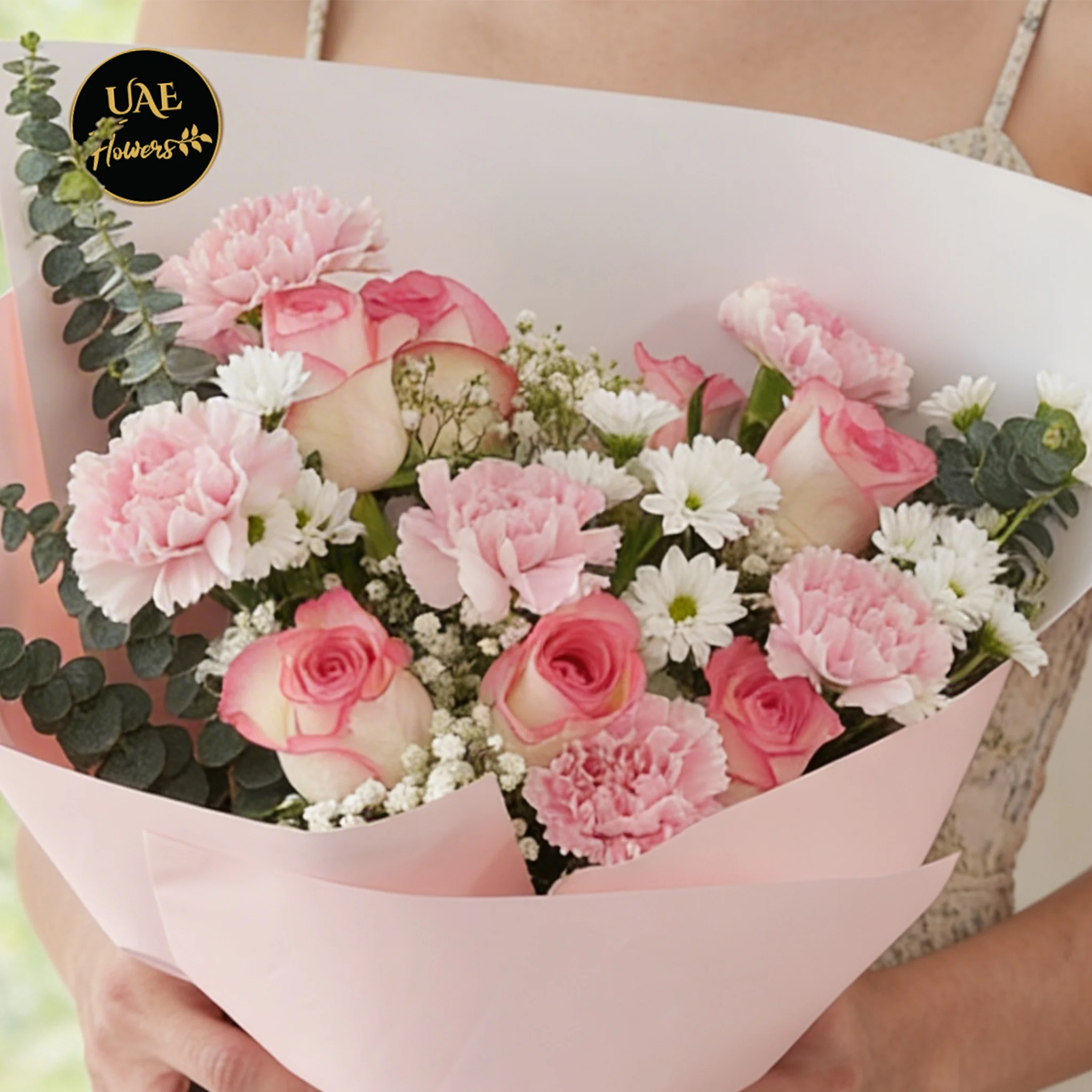 Bouquet of 7 pink roses, 6 pink carnations, 2 white chrysanthemums with green fillers in pink wrapping.