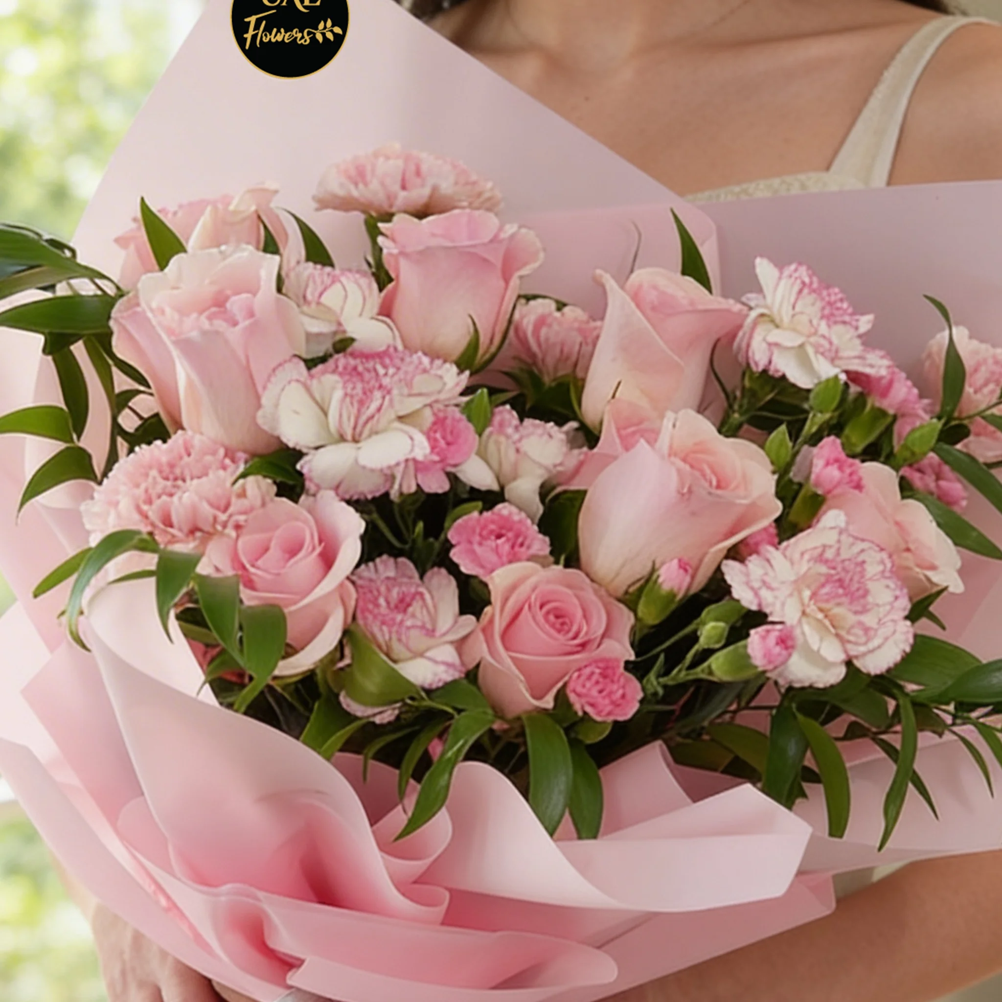 Bouquet of 6 pink roses, 6 pink carnations, 3 pink spray carnations with green fillers in pink wrapping.