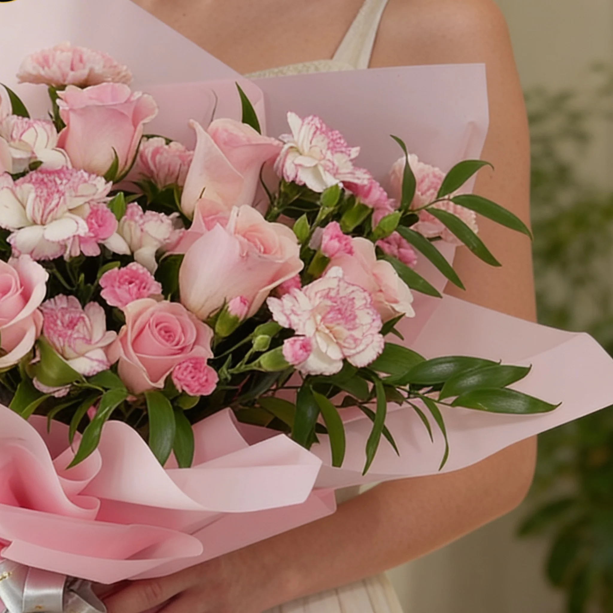 Bouquet of 6 pink roses, 6 pink carnations, 3 pink spray carnations with green fillers in pink wrapping.
