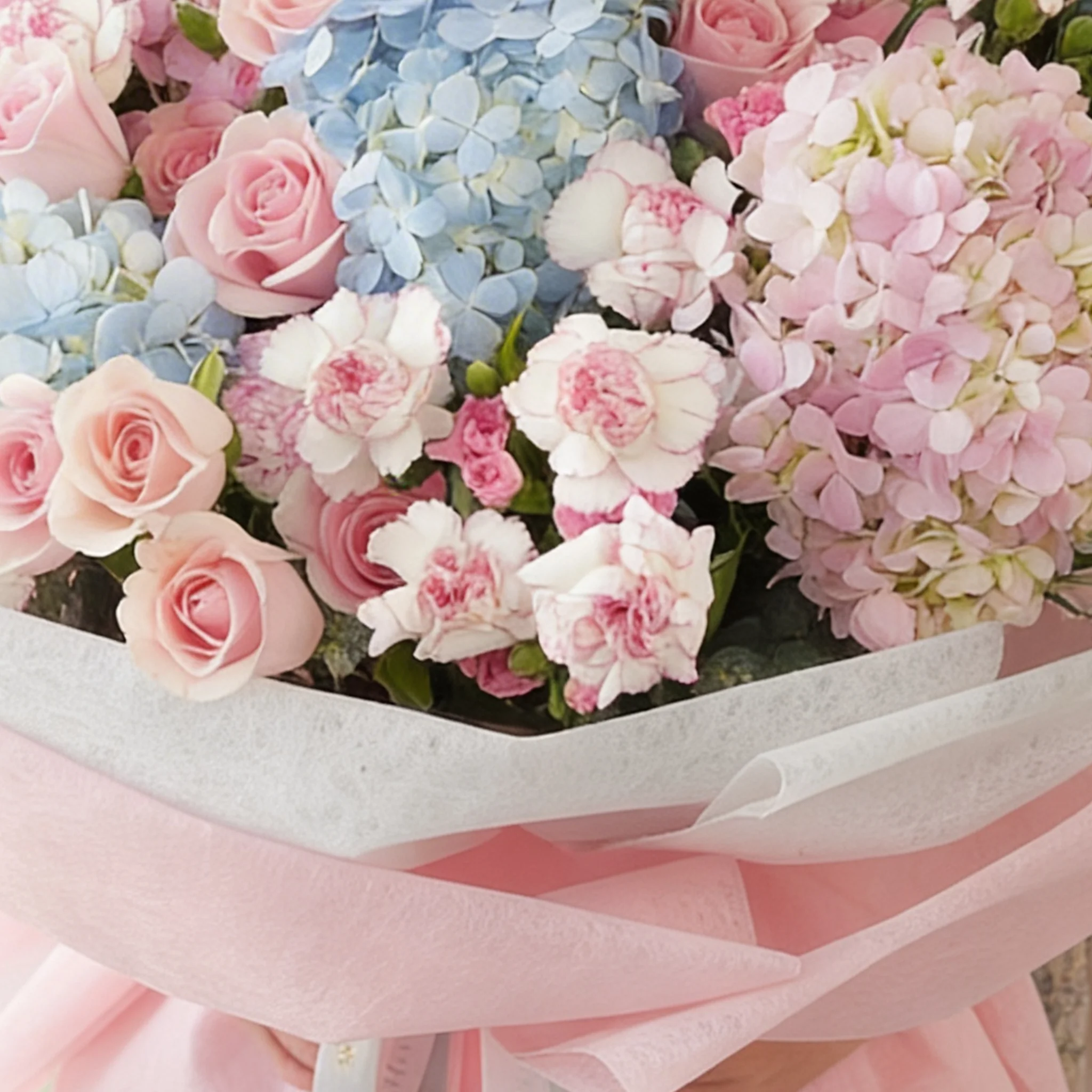 Bouquet of 4 blue hydrangeas, 2 pink hydrangeas, 30 pink roses, 30 pink carnations and 10 pink spray carnations with green fillers in pink wrapping.