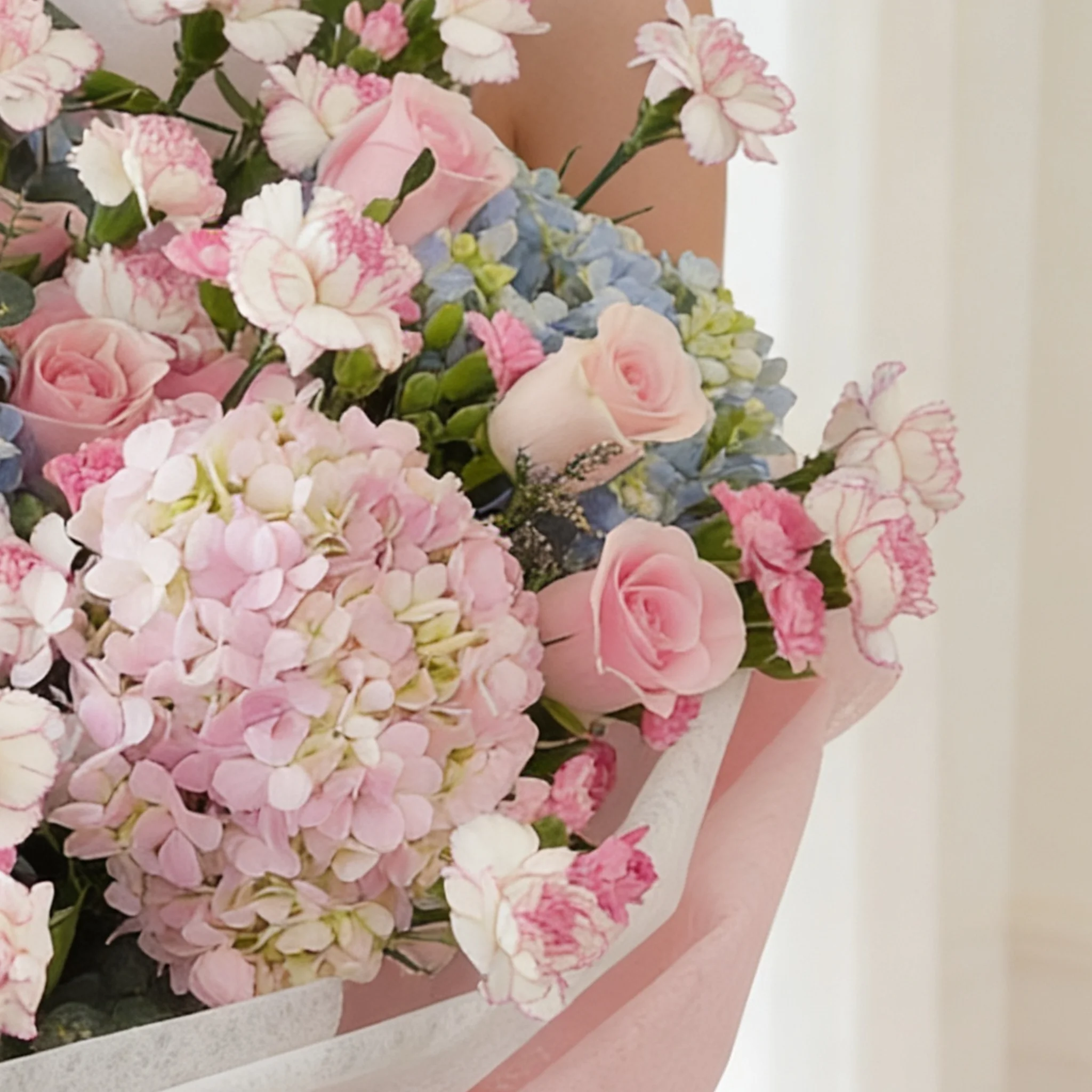 Bouquet of 4 blue hydrangeas, 2 pink hydrangeas, 30 pink roses, 30 pink carnations and 10 pink spray carnations with green fillers in pink wrapping.