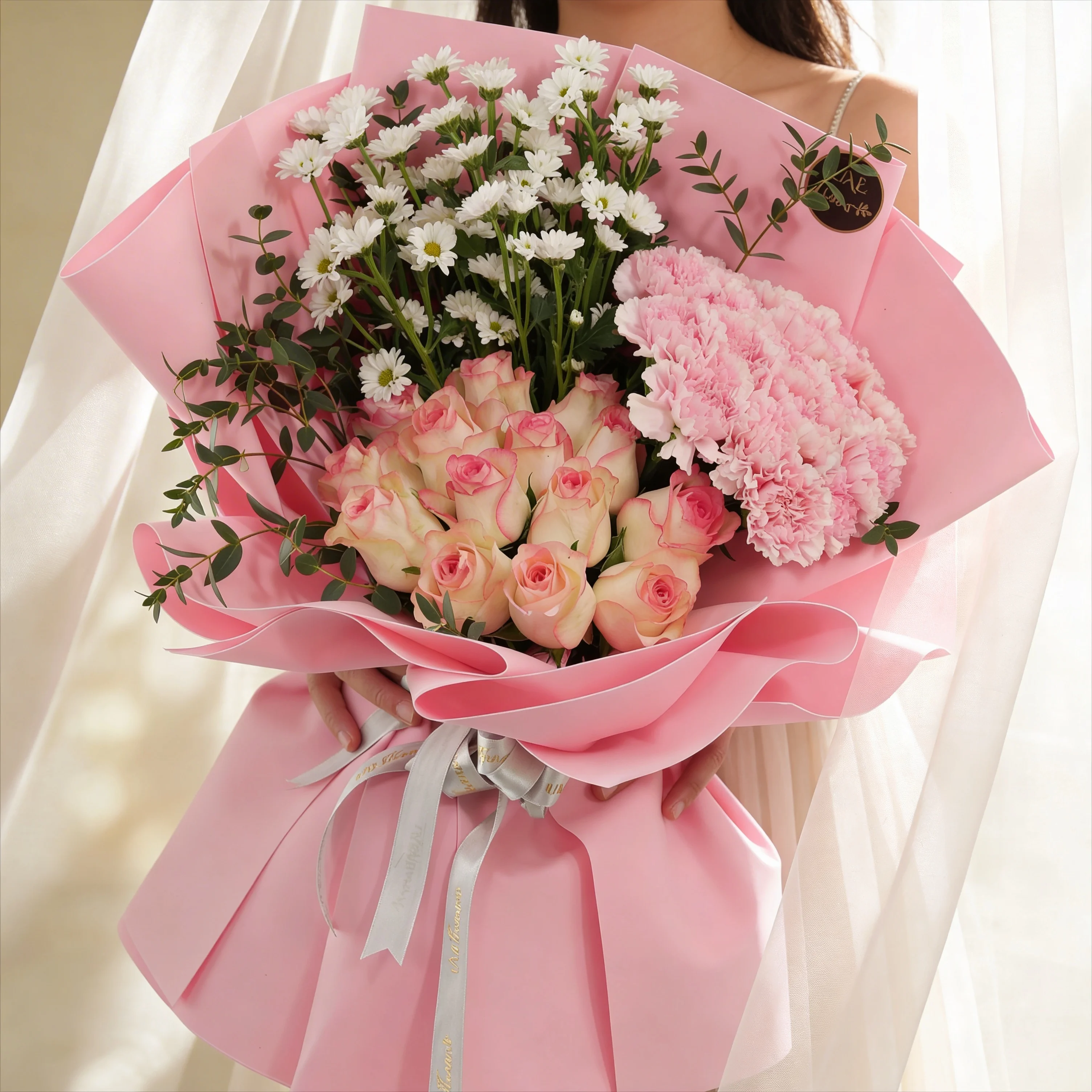 Bouquet of 15 pink carnations, 15 pink roses and 5 white chrysanthemums with green fillers in pink wrapping.
