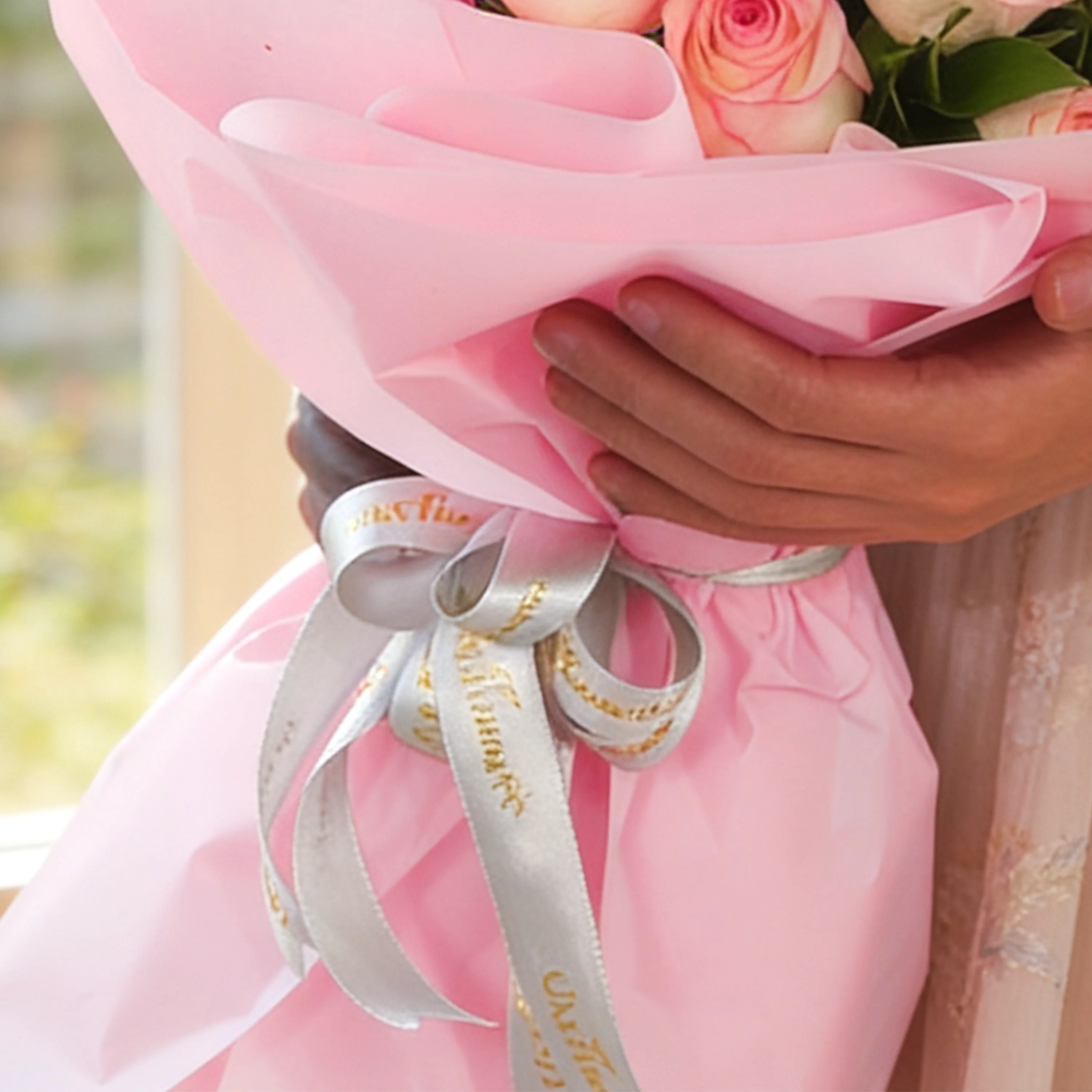 Bouquet of 12 pink roses with green fillers in pink wrapping paper.