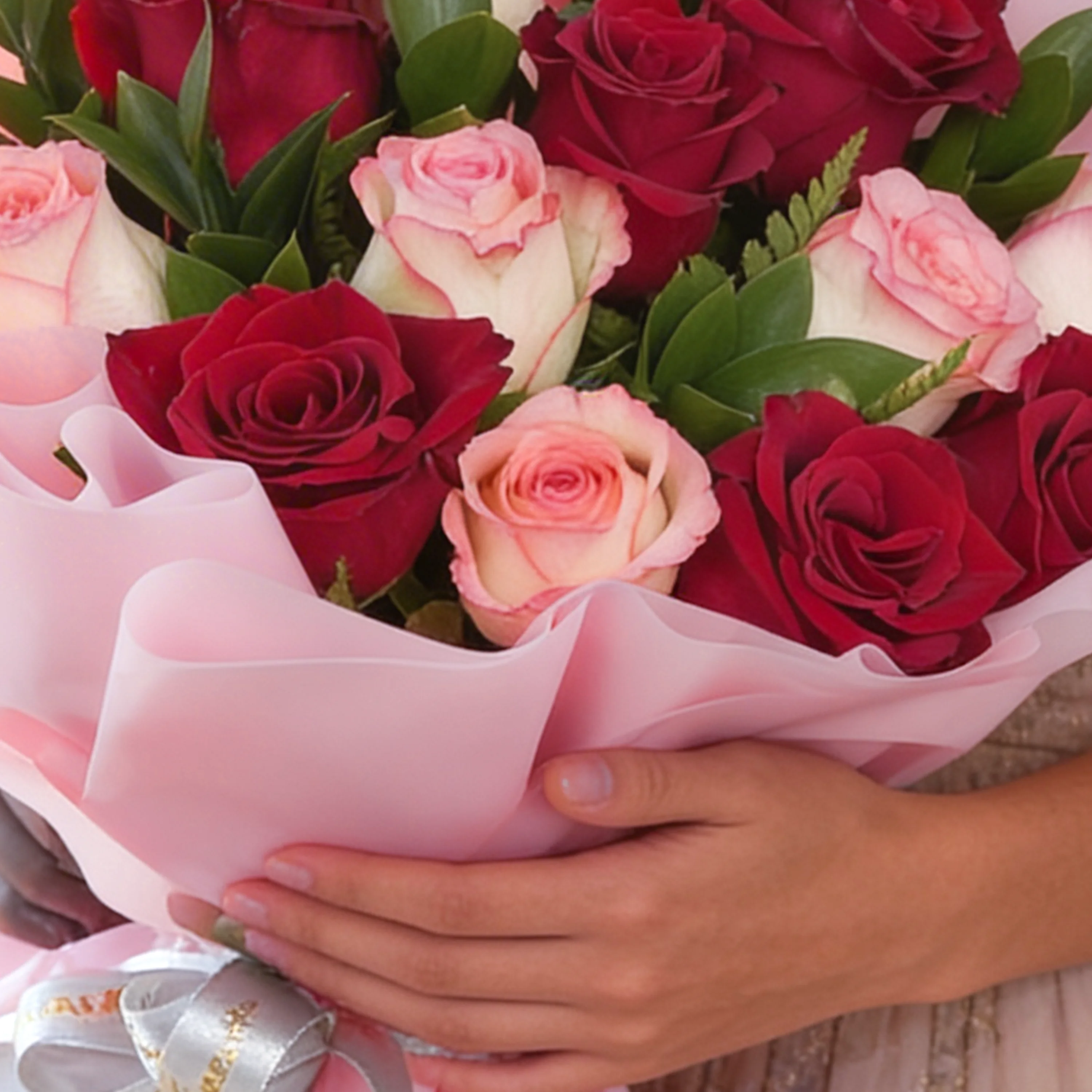 Bouquet of 12 red and pink roses with green fillers in pink wrapping paper.