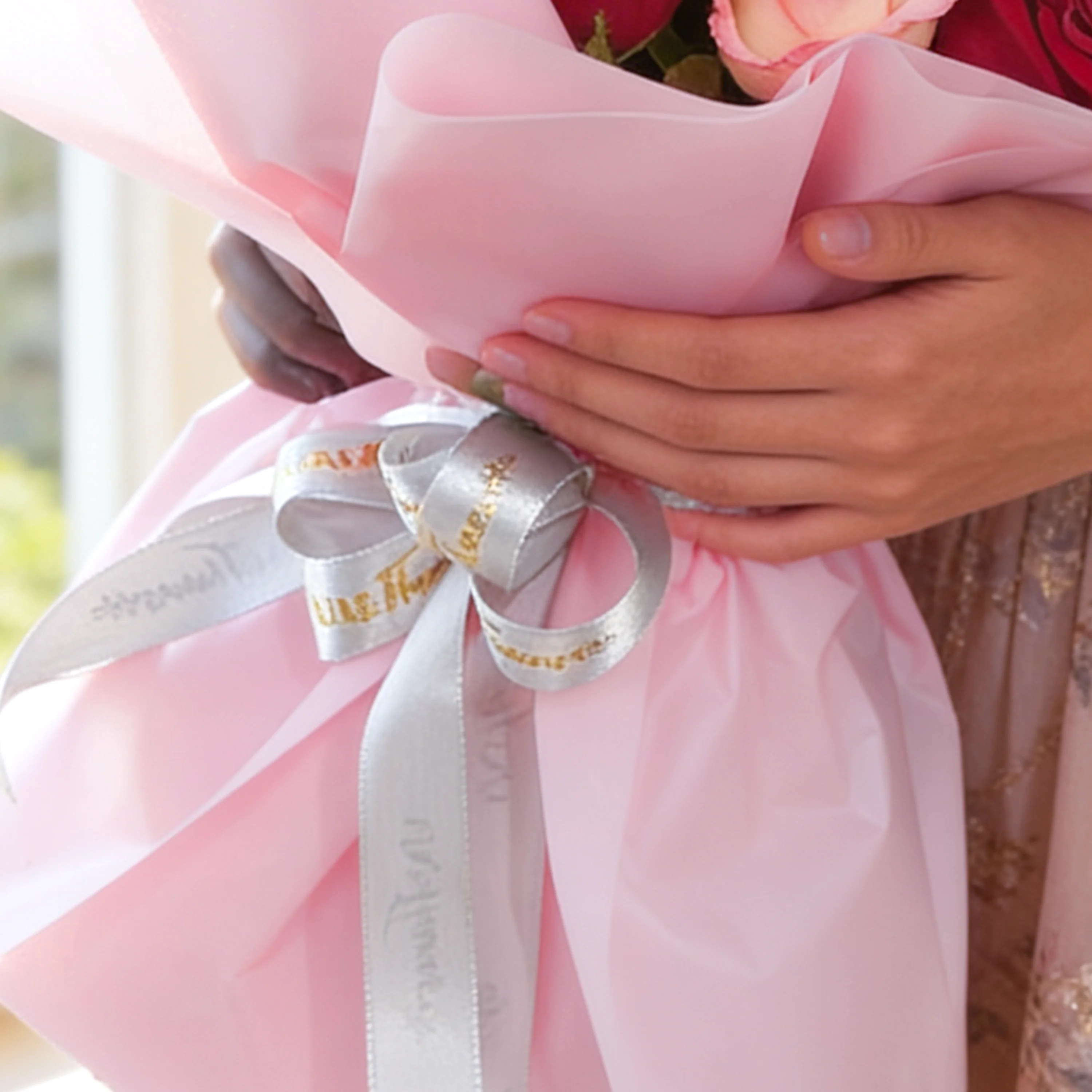 Bouquet of 12 red and pink roses with green fillers in pink wrapping paper.