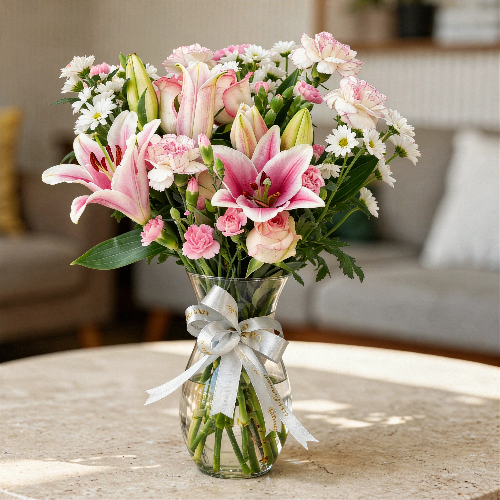 6 pink roses, 6 pink carnations, 2 pink lilies and 4 pink spray carnations with green fillers in a glass vase.