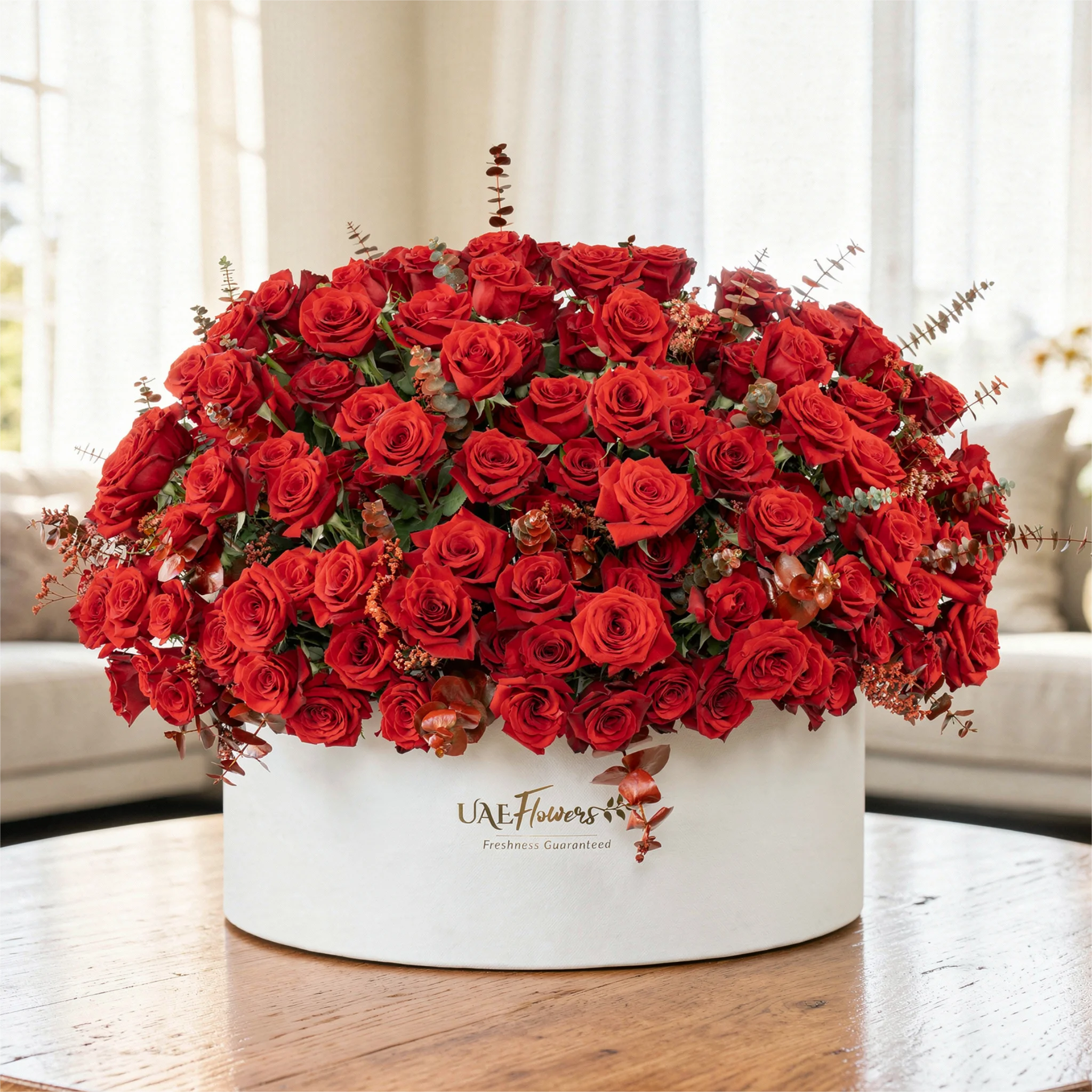 Full round arrangement of 250 red roses in a white round box.