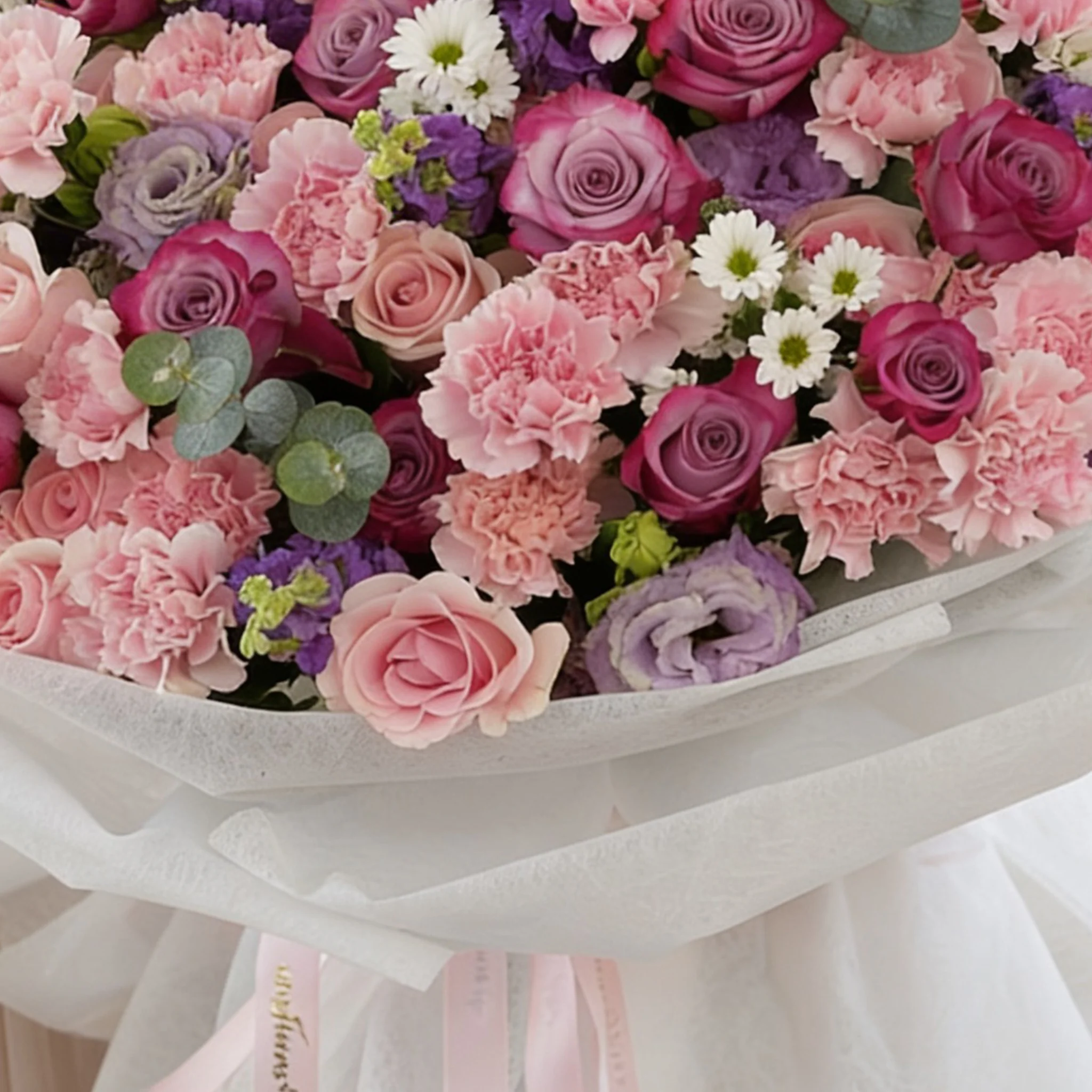 Bouquet of 10 purple matthiola, 10 white chrysanthemums, 10 purple lisianthus, 30 pink carnations, 20 purple roses and 40 pink roses with green fillers in nice wrapping.
