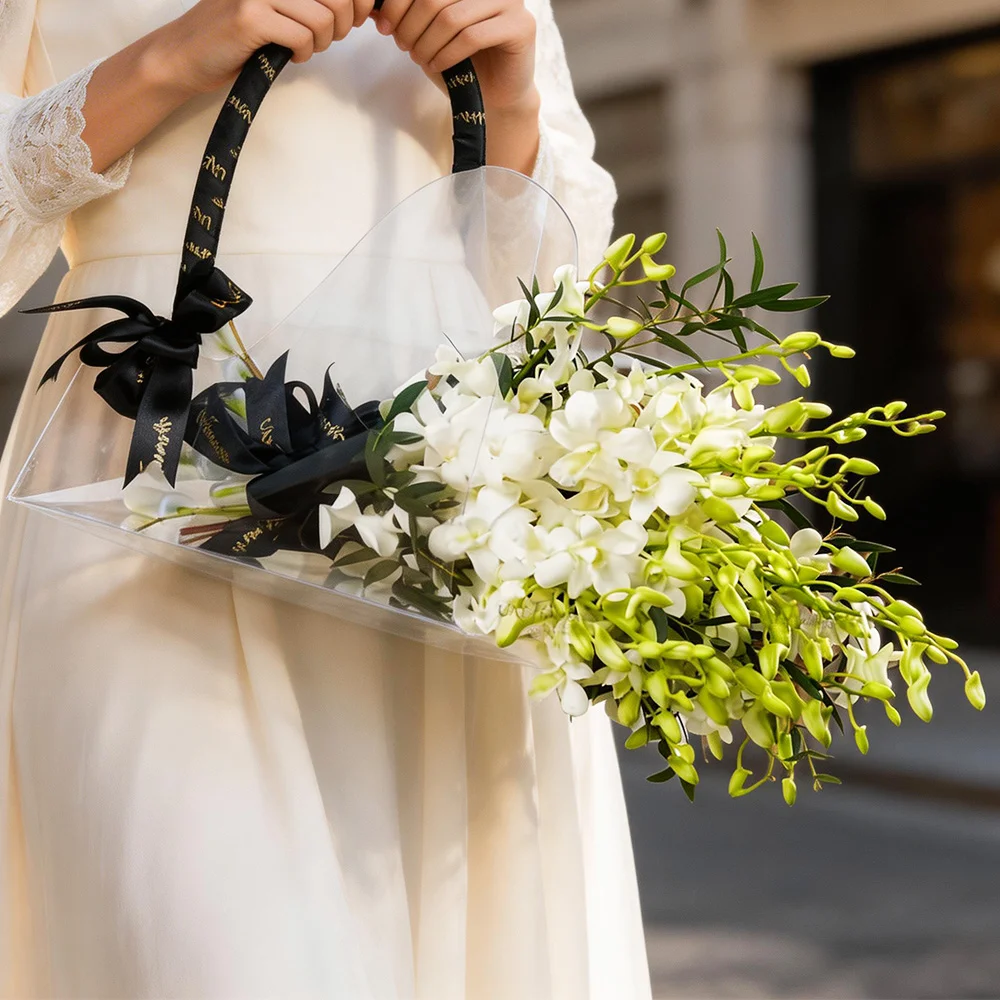 bag with 10 white orchids, tied with black ribbons