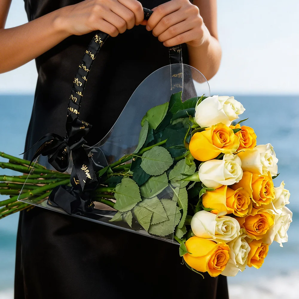 7 yellow and 7 white roses in a chic acrylic bag, tied with a black ribbon