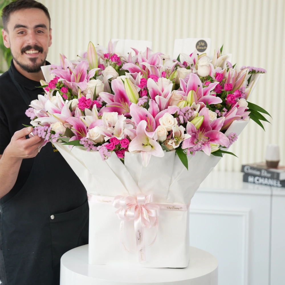 Bouquet of 10 pink lilies, 30 white roses, 10 pink spray roses with green fillers tied with ribbons.