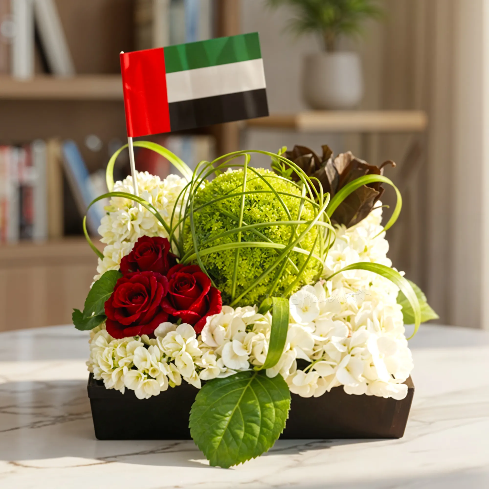 2 white hydrangea, 8 green chrysanthemums, 3 red roses, 2 sprayed black roses, steel grass, and palm leaves in a square black box