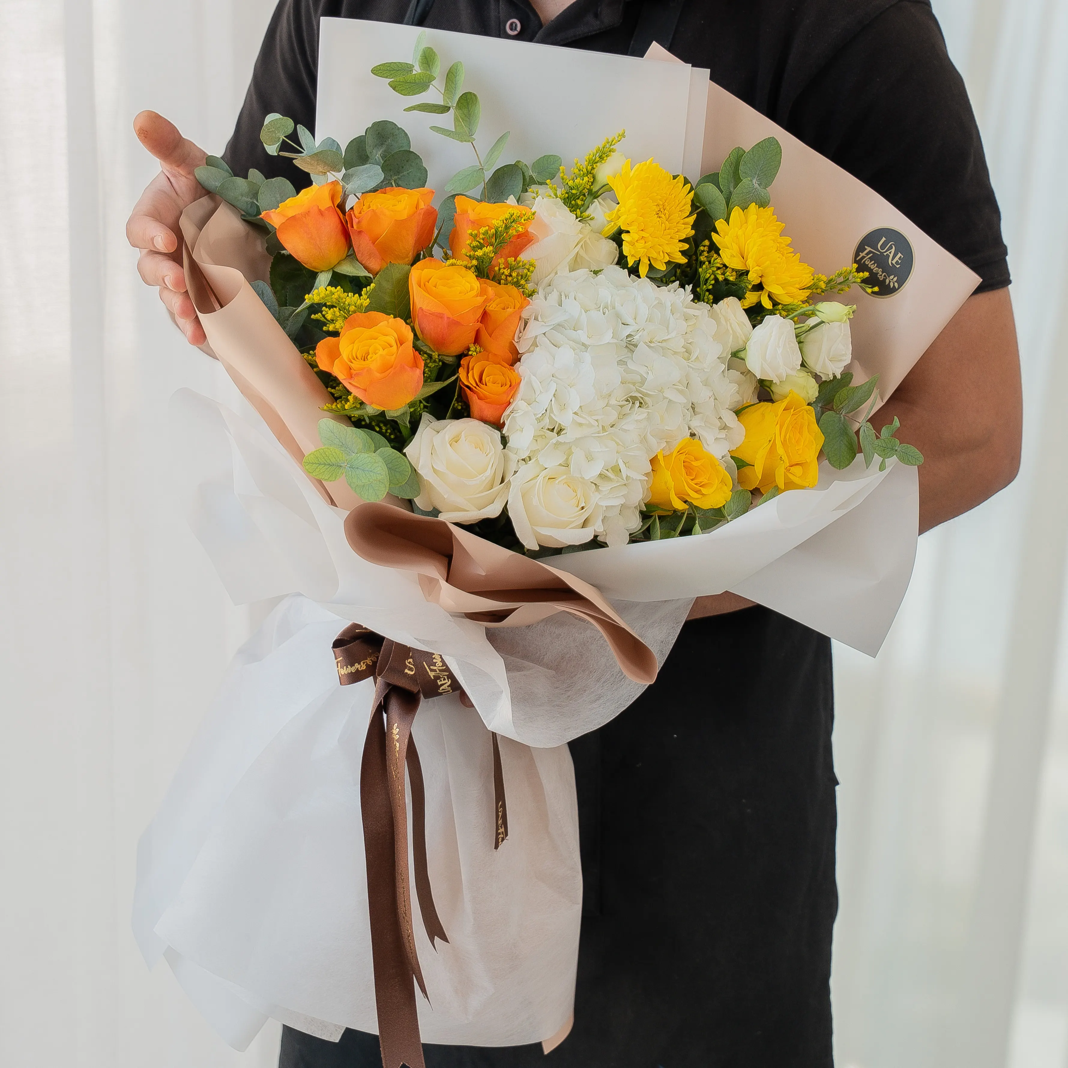 Orange, yellow, and white flower bouquet wrapped in elegant paper for Diwali by UAE Flowers Dubai