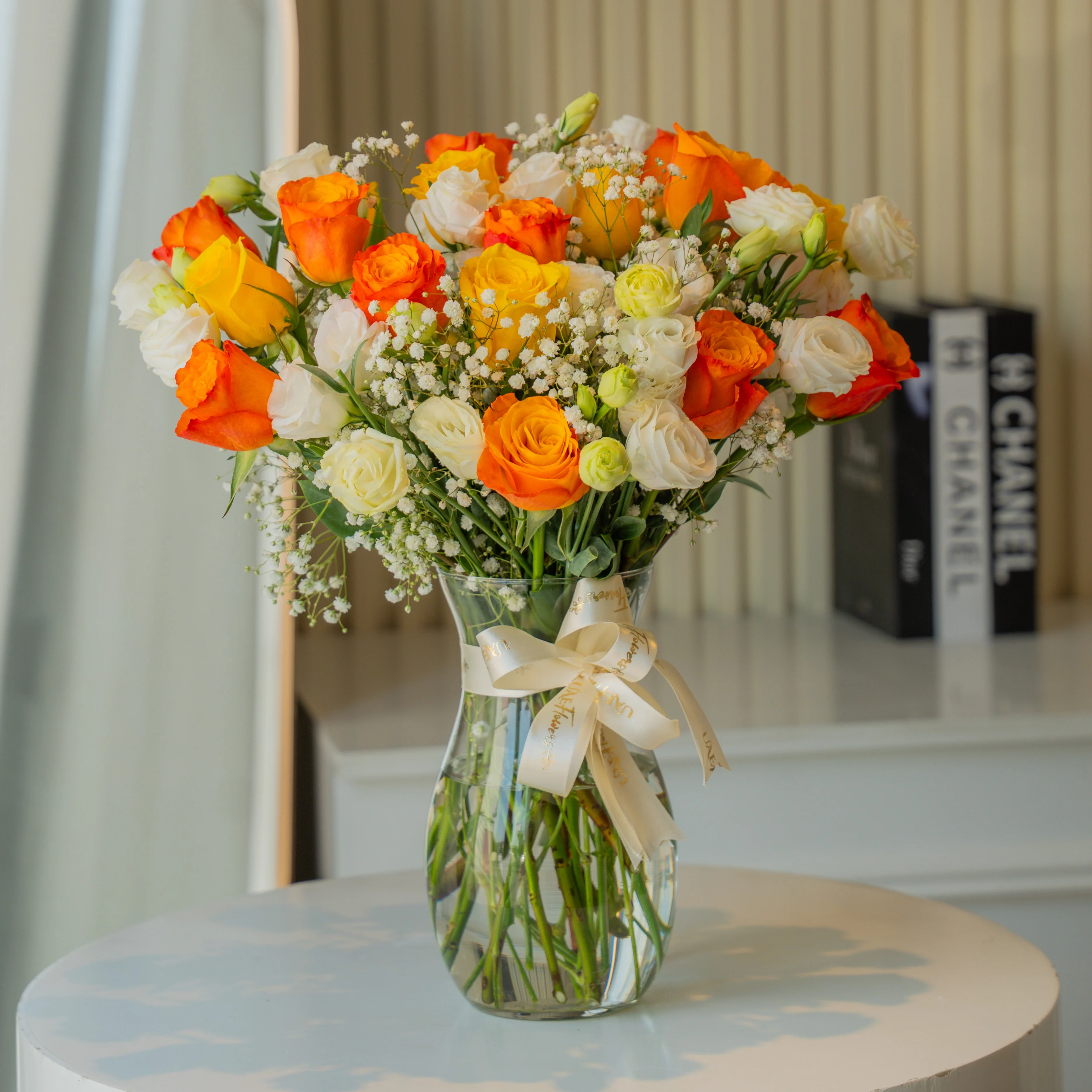 Orange, yellow, and white roses in glass vase for Diwali by UAE Flowers Dubai