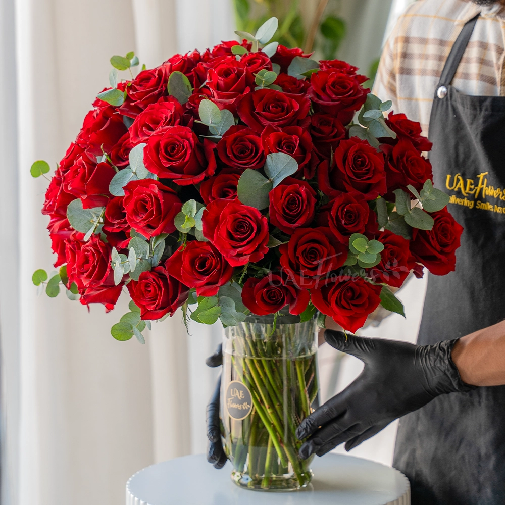 Vase of 50 red roses with eucalyptus leaves