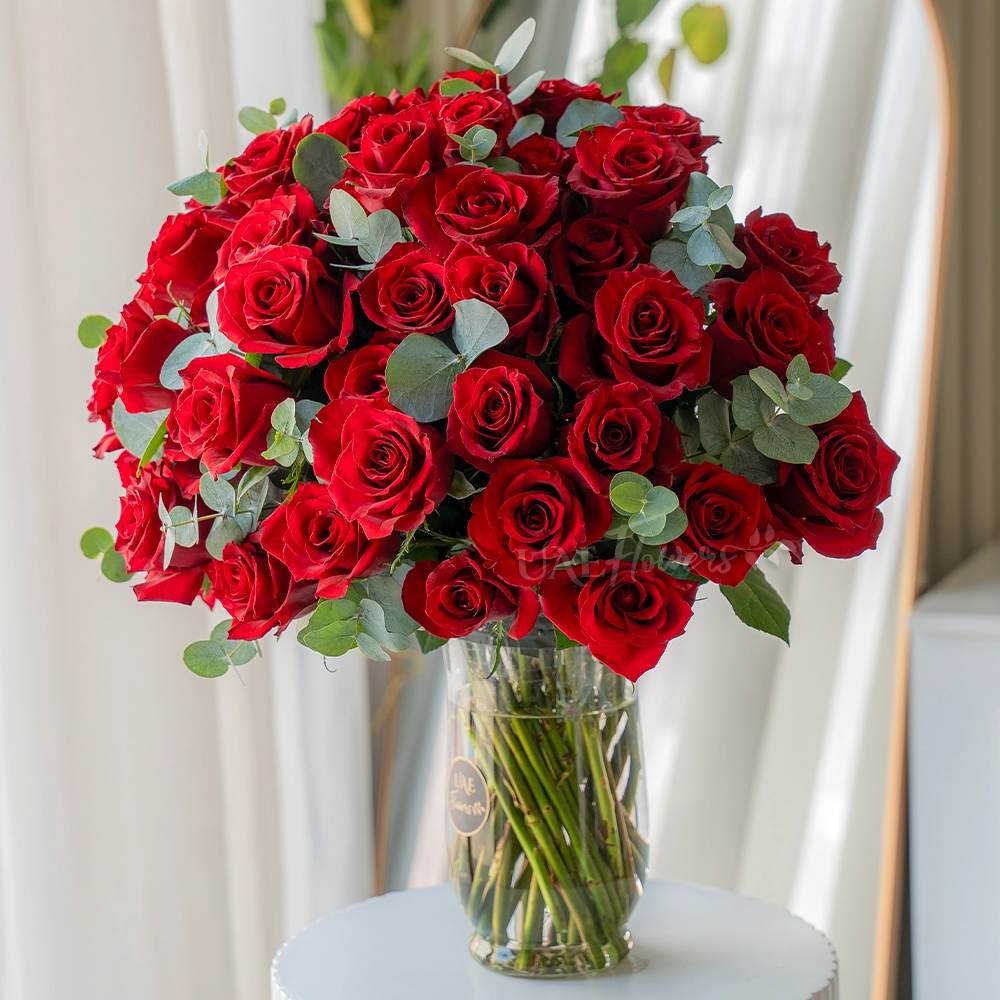 Vase of 50 red roses with eucalyptus leaves
