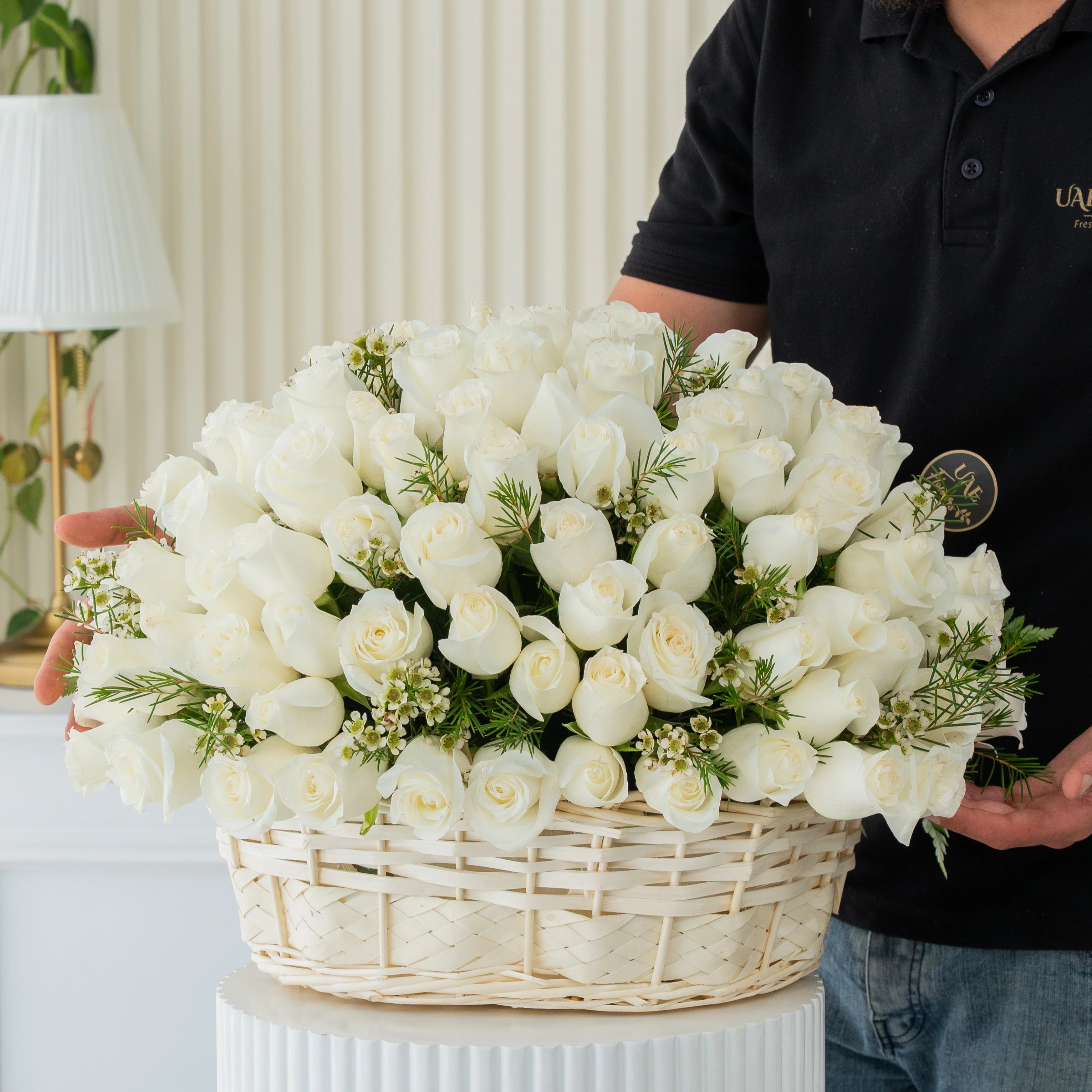 A basket arrangement of 40 white roses and fillers