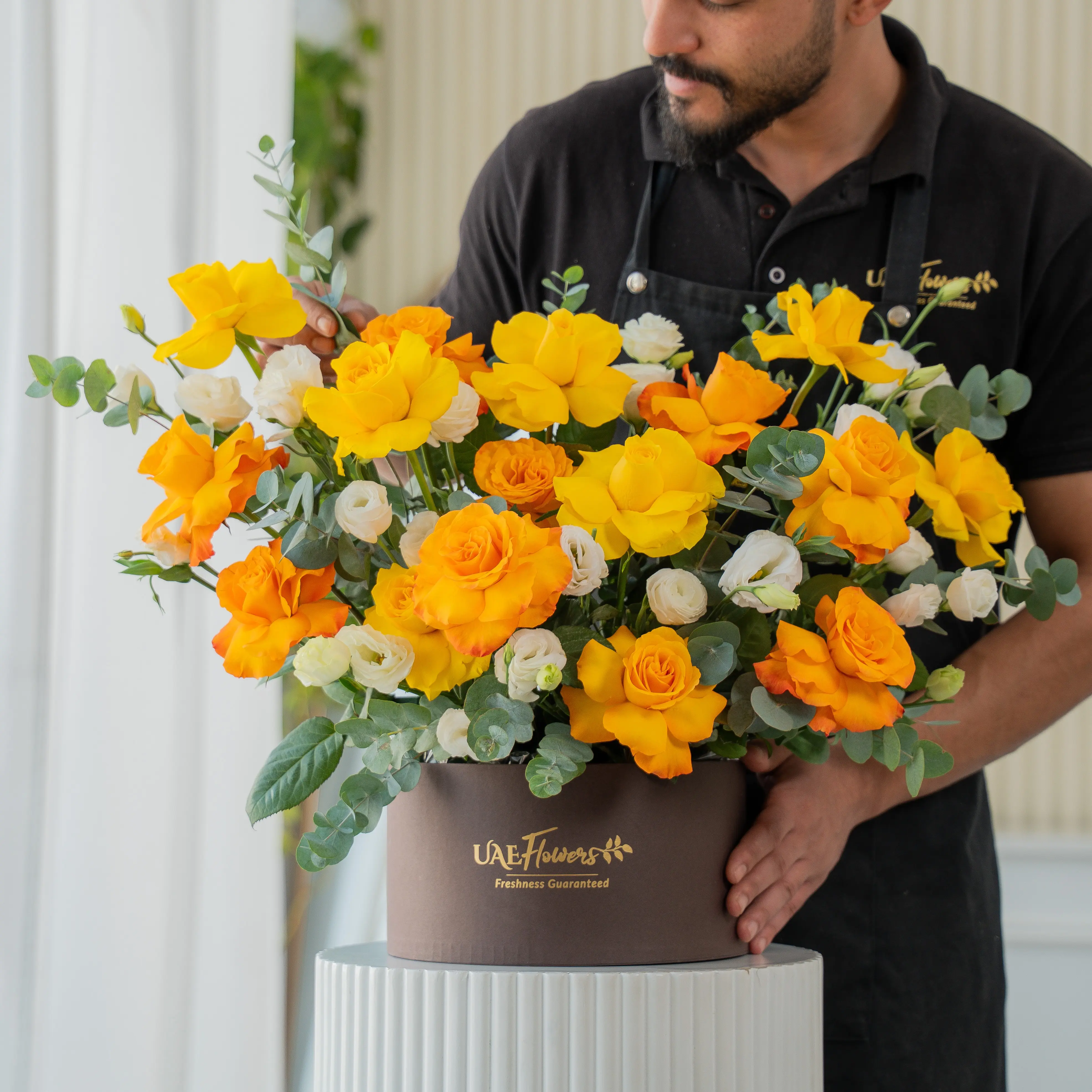 Yellow, orange, and white roses in luxury hatbox for Diwali by UAE Flowers Dubai