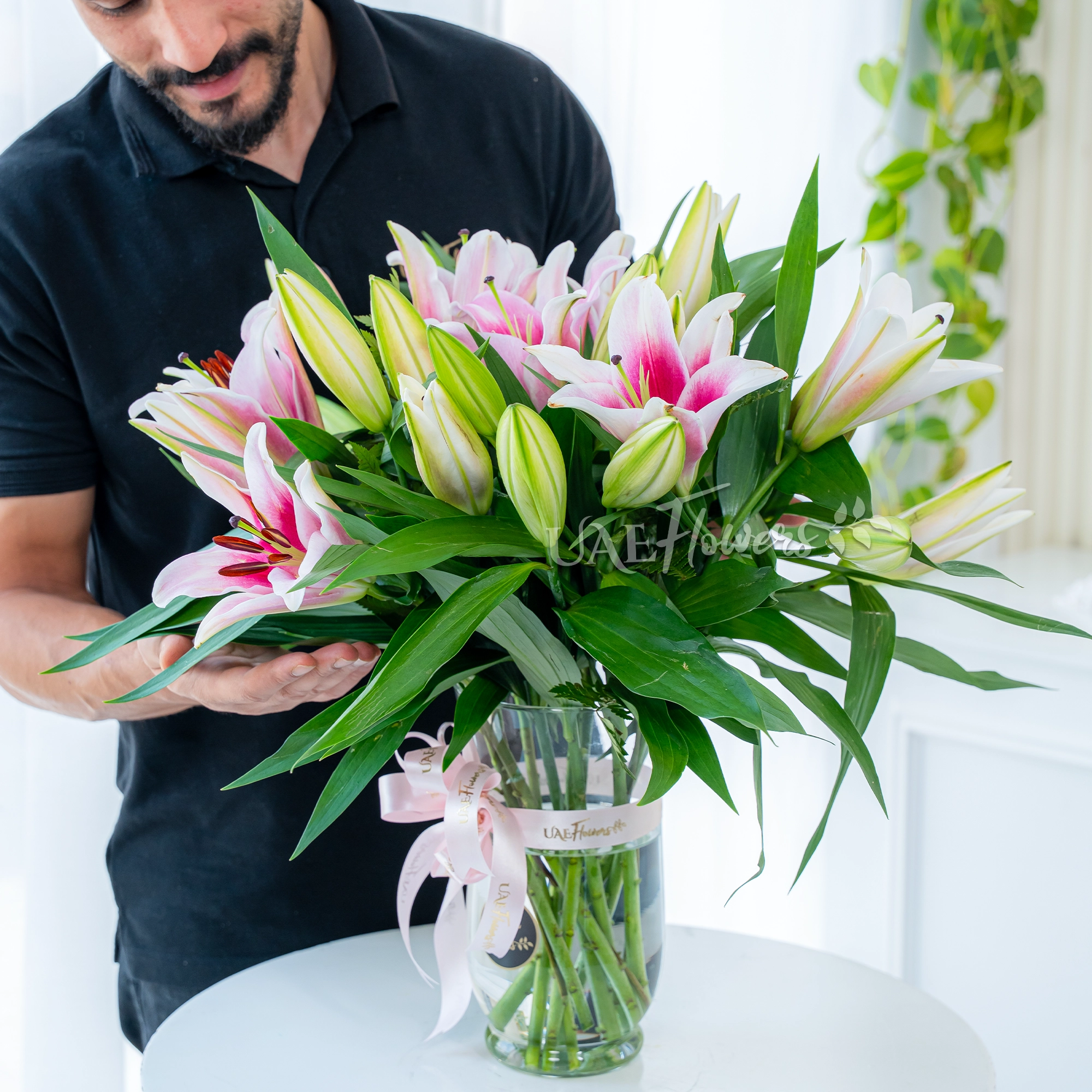 5 pink lilies with fillers in a glass vase
