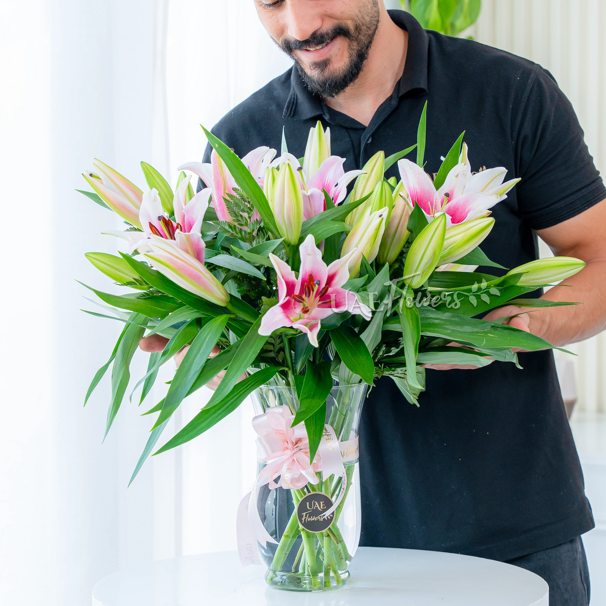 5 pink lilies with fillers in a glass vase