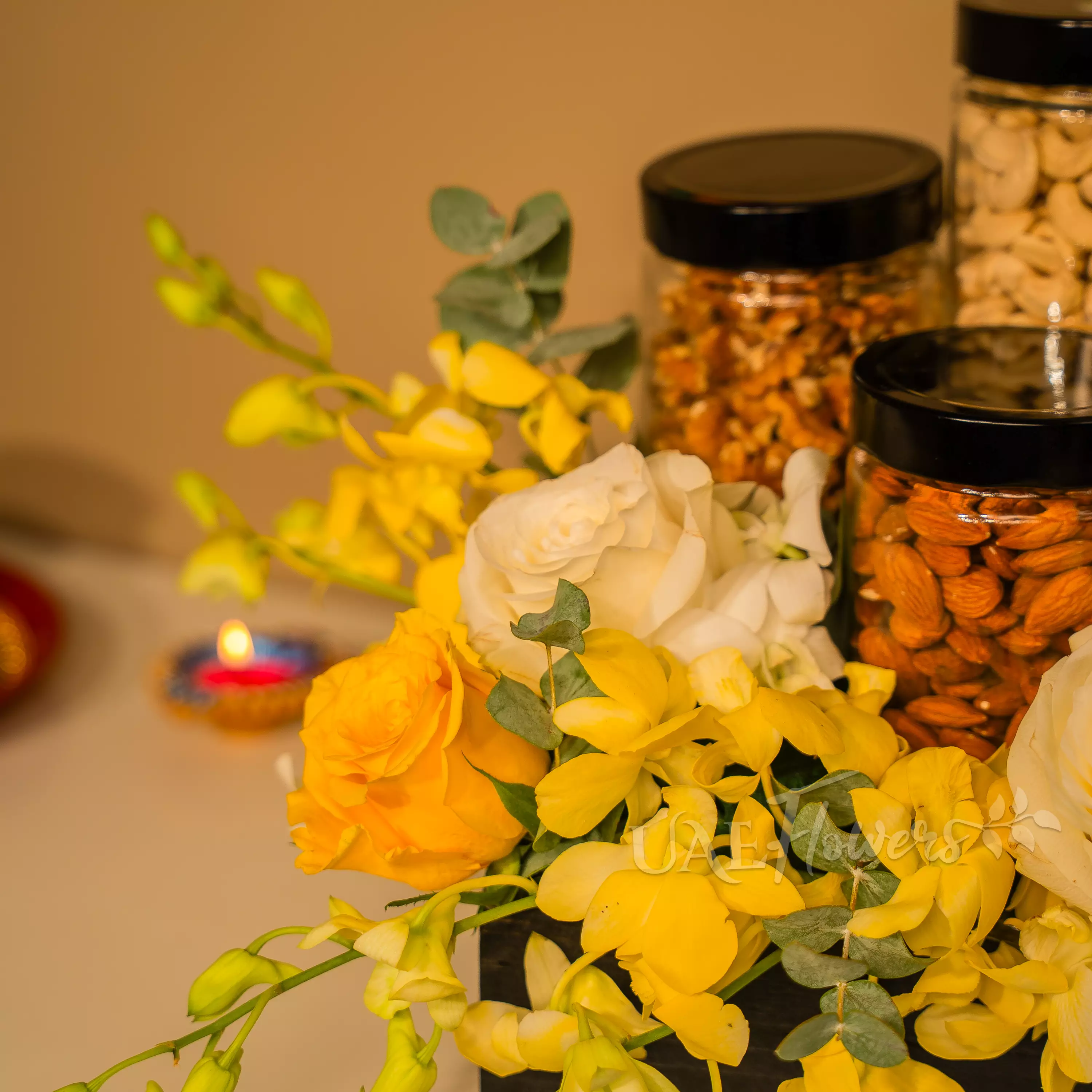 Yellow and white flowers with dry fruit jars in Diwali hamper by UAE Flowers Dubai