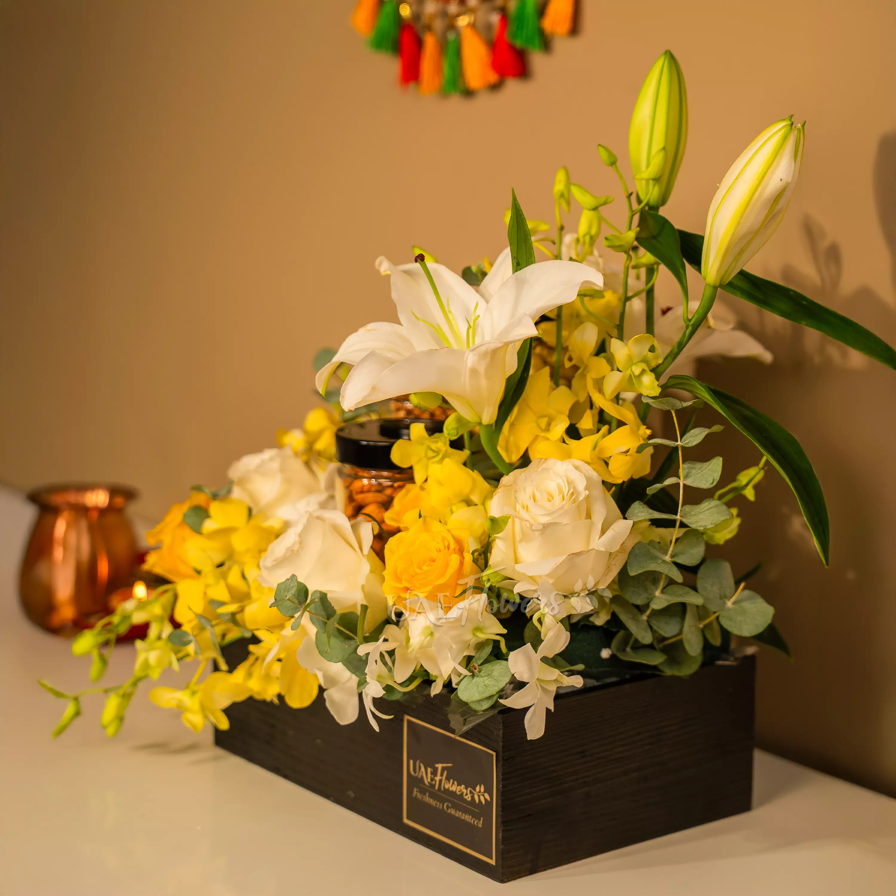 Yellow and white flowers with dry fruit jars in Diwali hamper by UAE Flowers Dubai