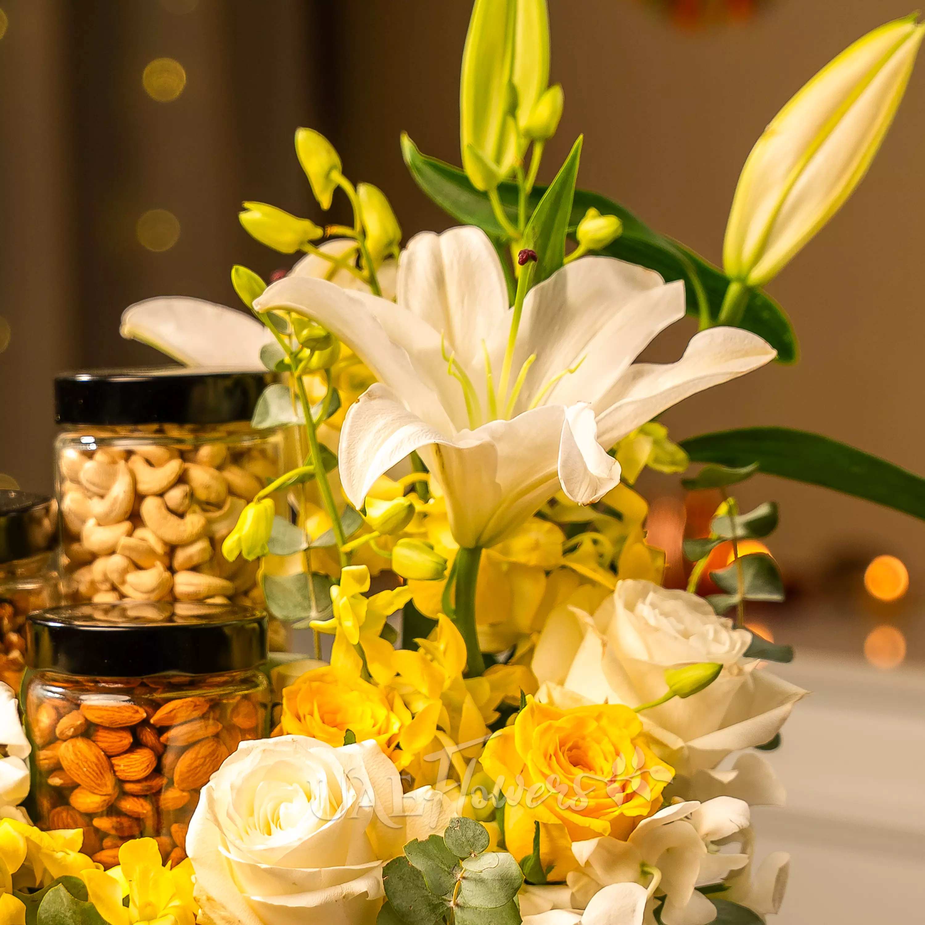 Yellow and white flowers with dry fruit jars in Diwali hamper by UAE Flowers Dubai