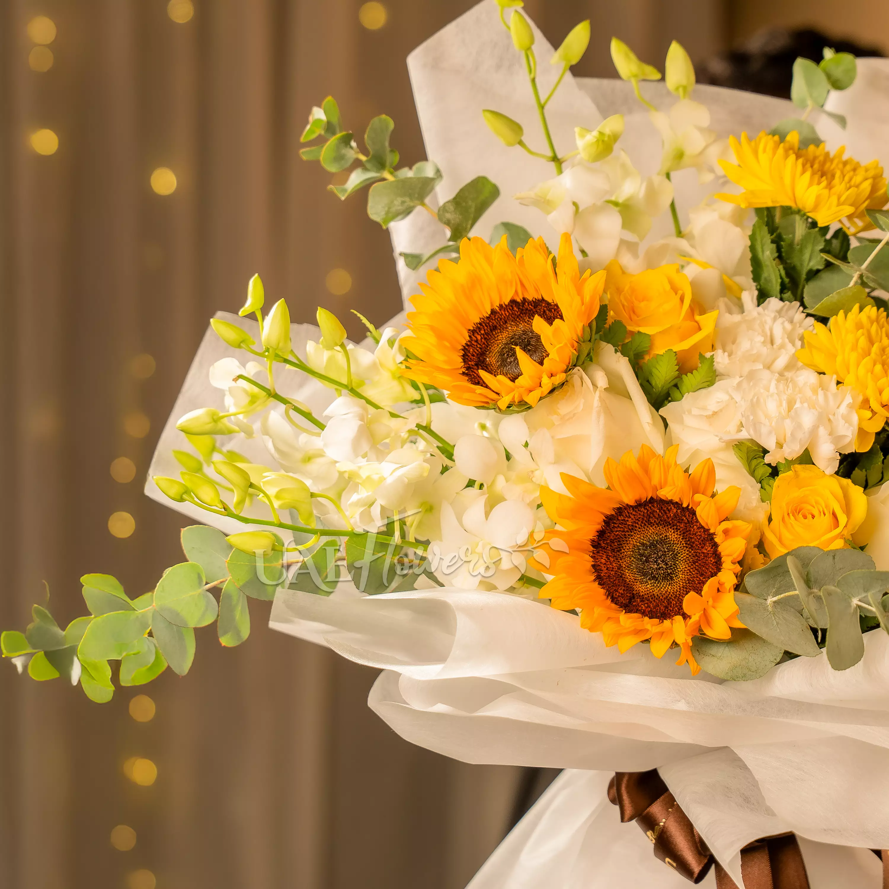 Man holding sunflower and orchid bouquet wrapped for Diwali by UAE Flowers Dubai