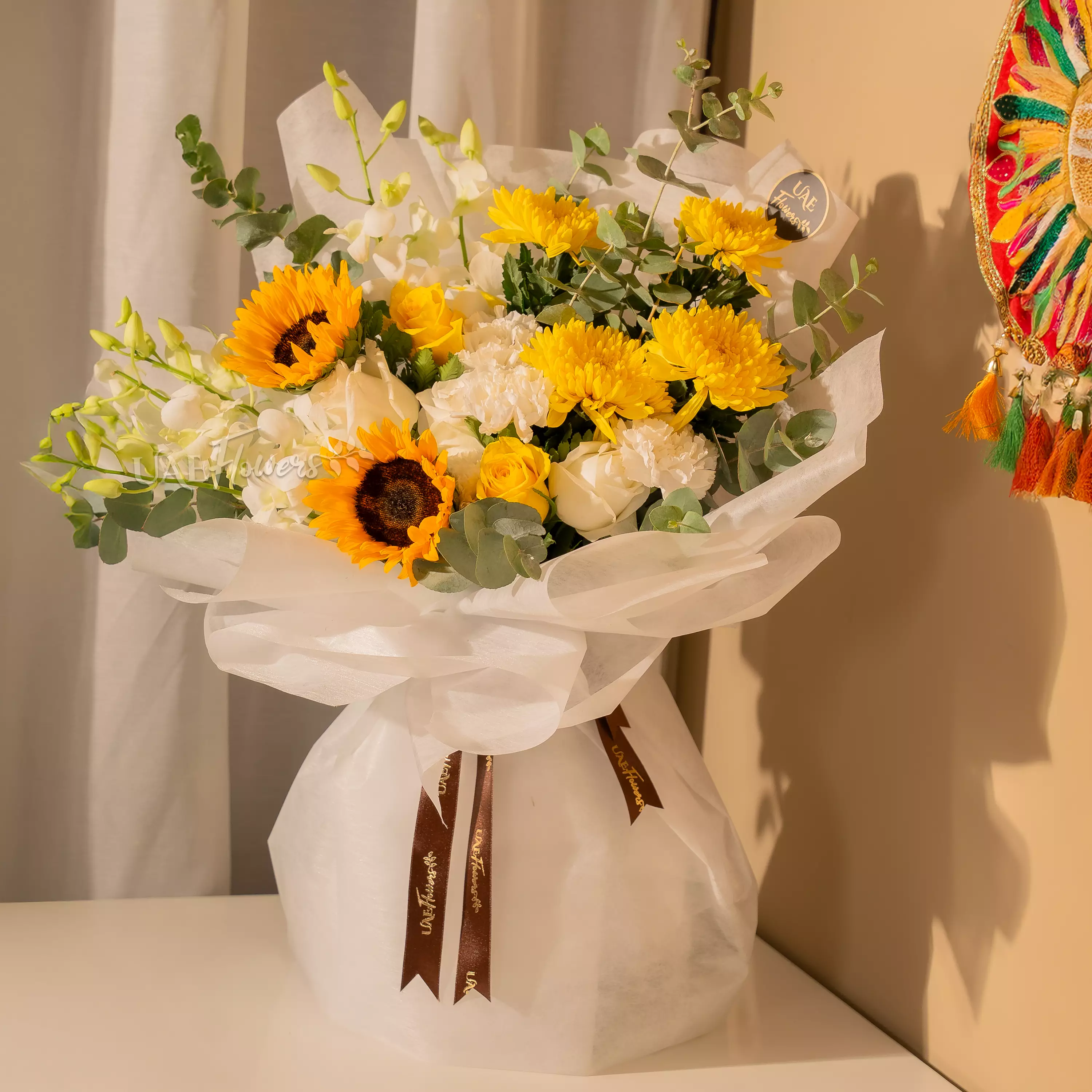 Man holding sunflower and orchid bouquet wrapped for Diwali by UAE Flowers Dubai