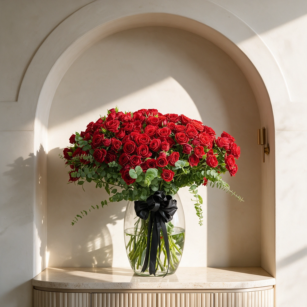 40 red spray roses with eucalyptus in a glass vase.