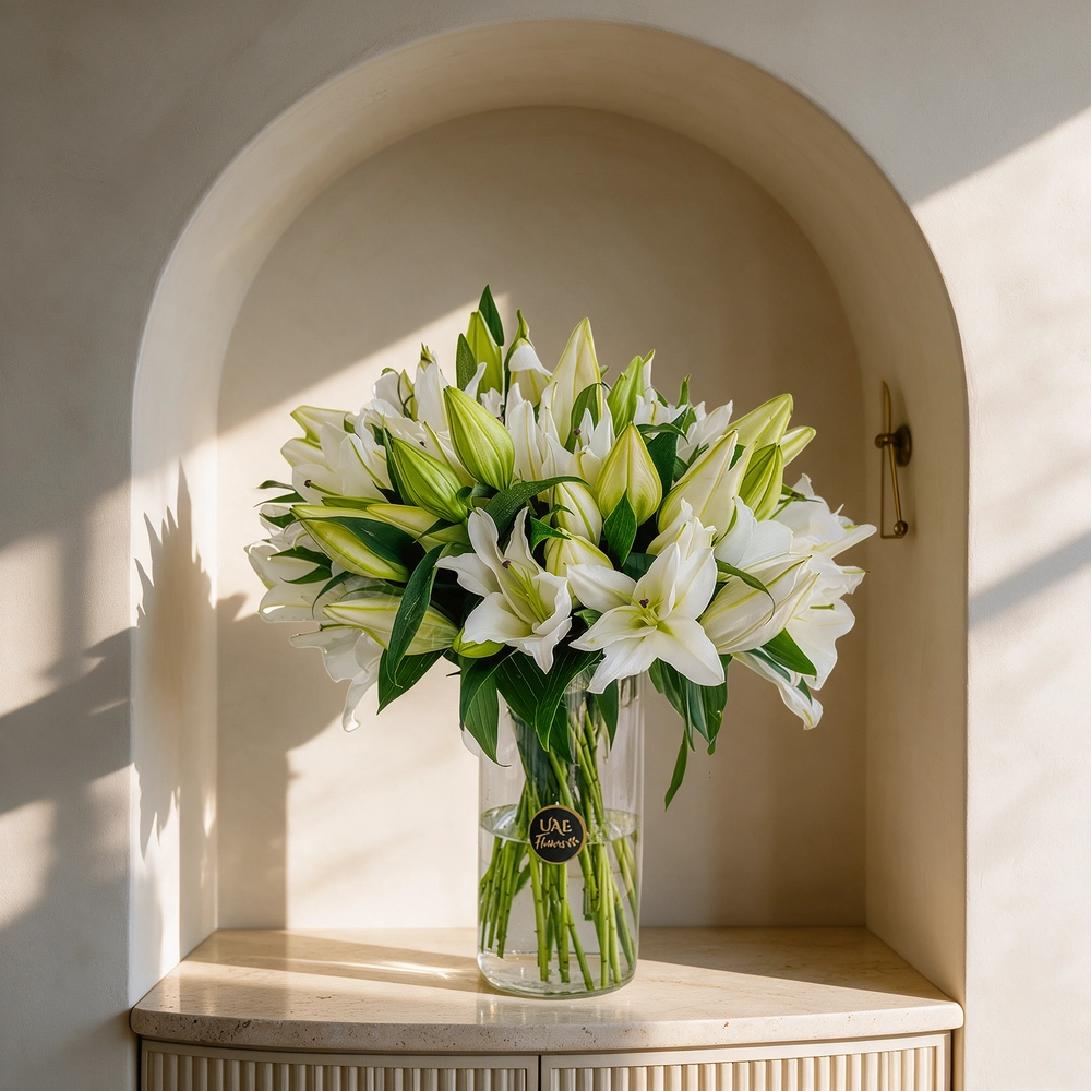 15 white lilies with green fillers in a glass vase