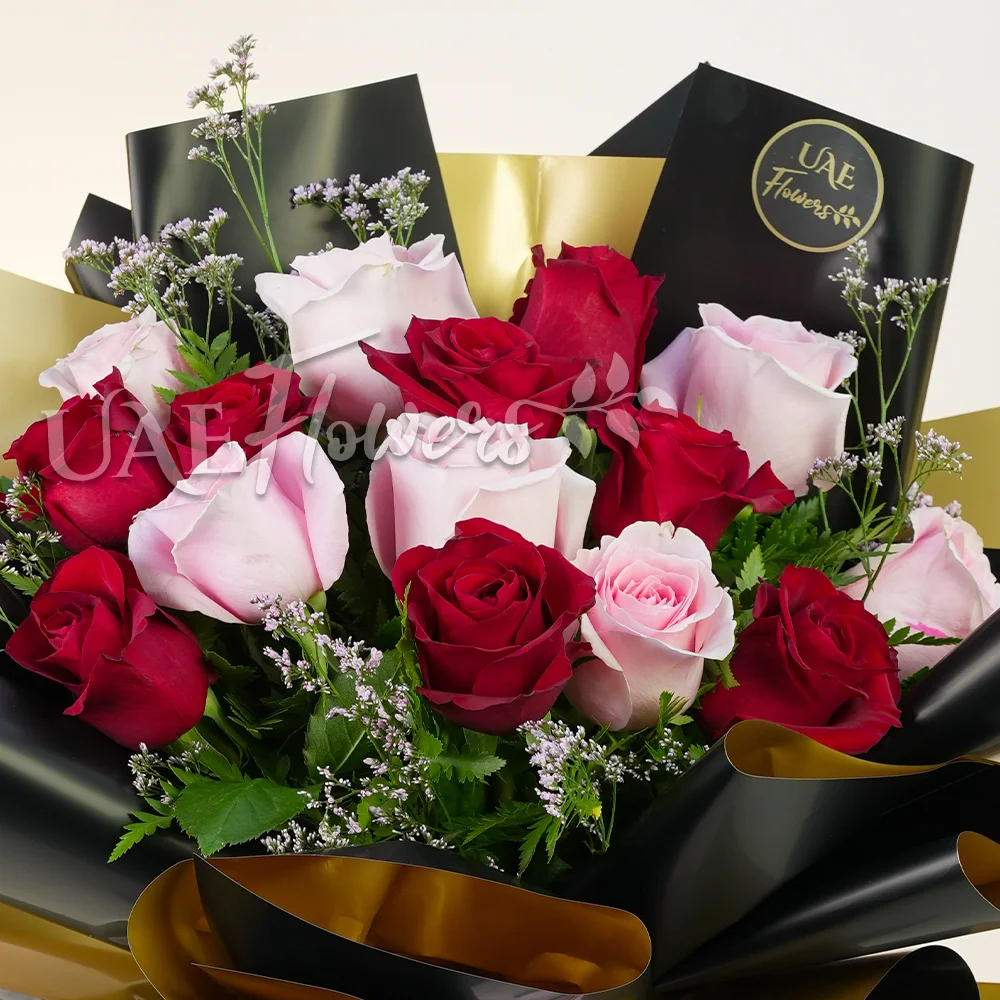 A bouquet of 20 pink and peach roses with green fillers and eucalyptus leaves, baby's breath in pink wrapping tied with pink ribbon