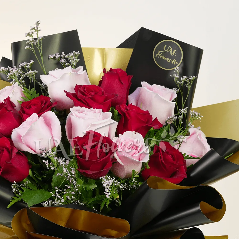 A bouquet of 20 pink and peach roses with green fillers and eucalyptus leaves, baby's breath in pink wrapping tied with pink ribbon