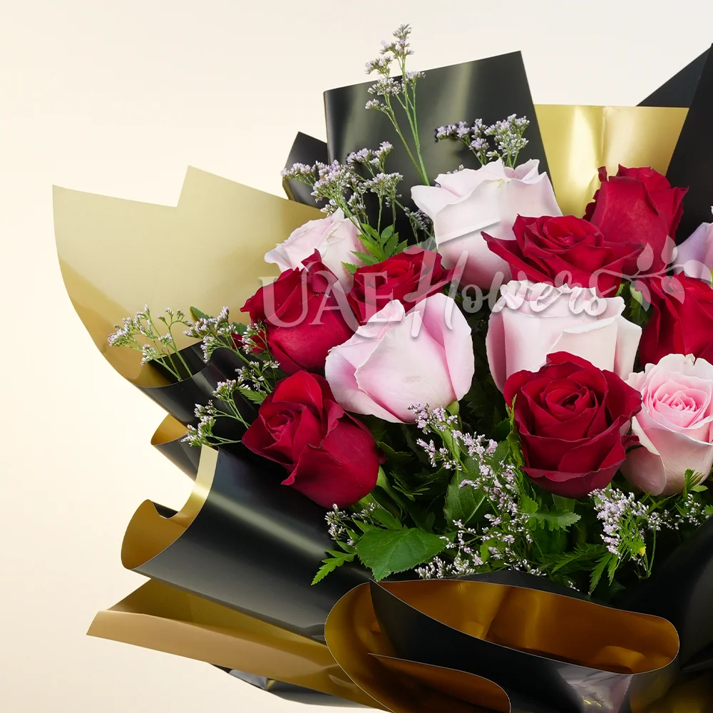 A bouquet of 20 pink and peach roses with green fillers and eucalyptus leaves, baby's breath in pink wrapping tied with pink ribbon