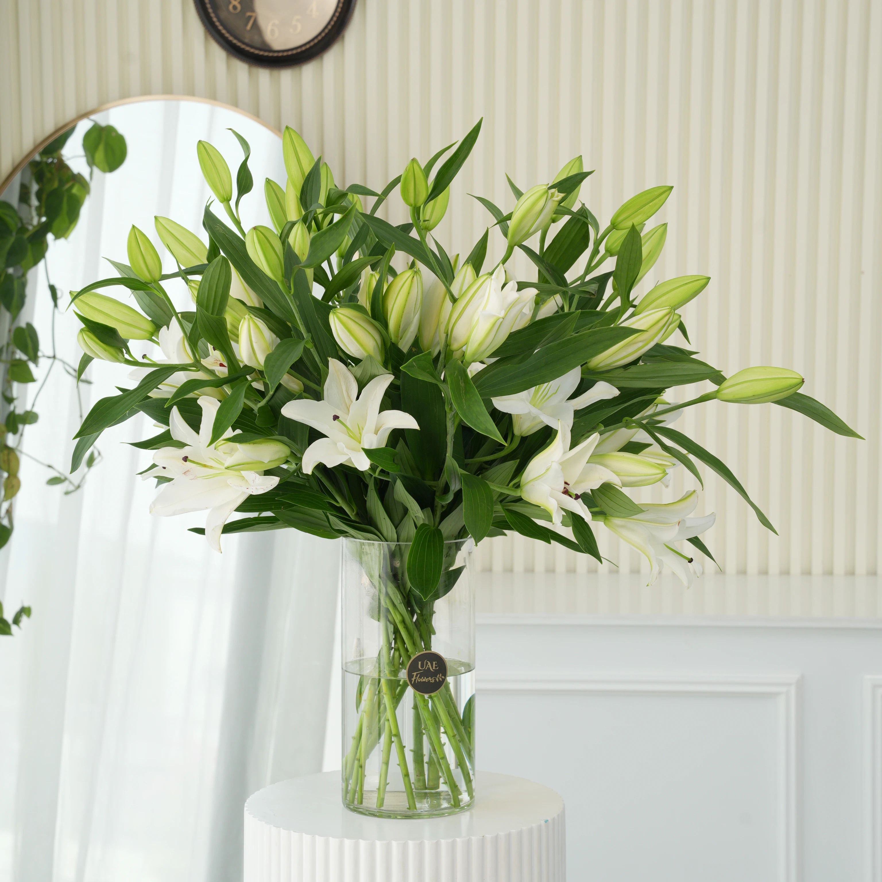 15 white lilies with green fillers in a glass vase