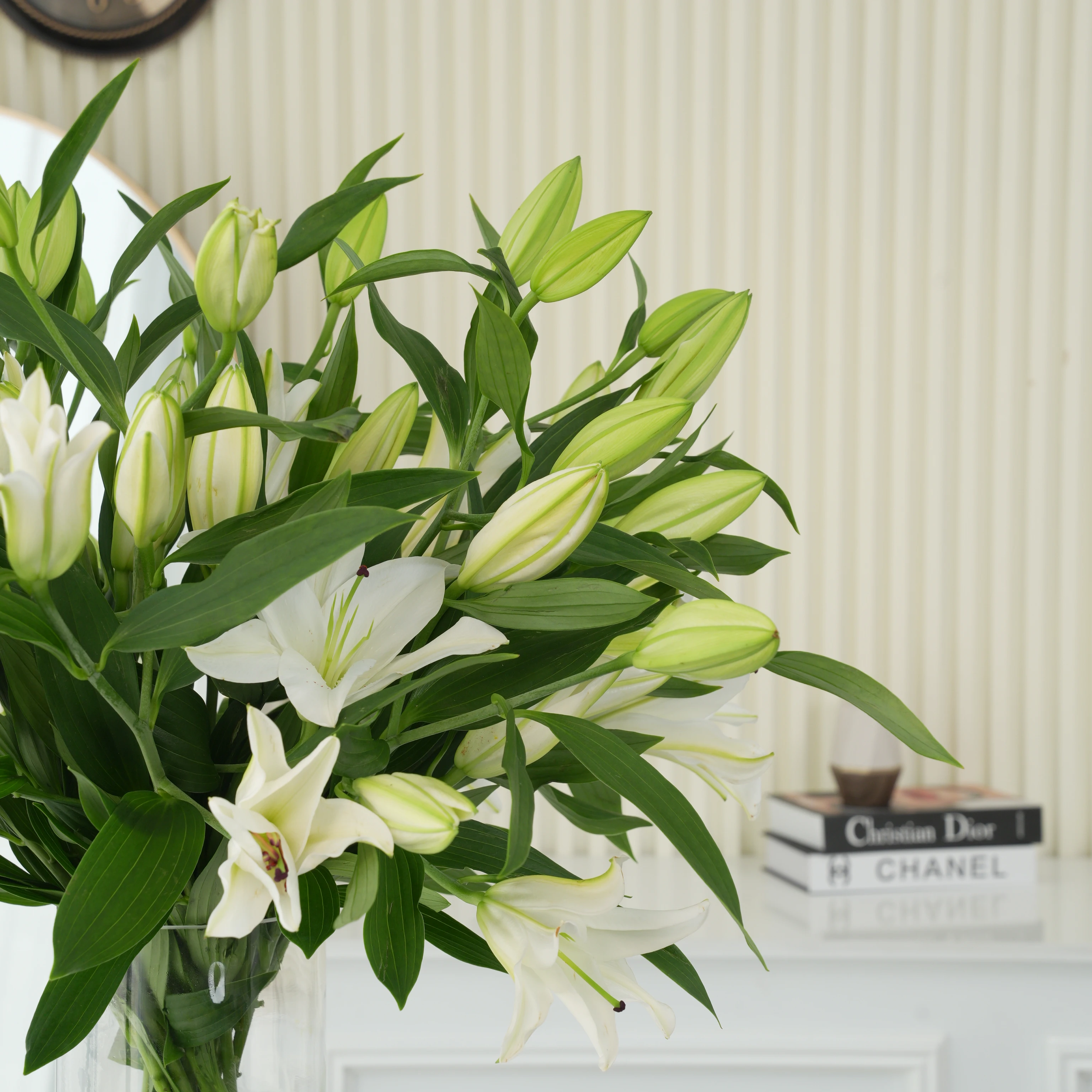 15 white lilies with green fillers in a glass vase