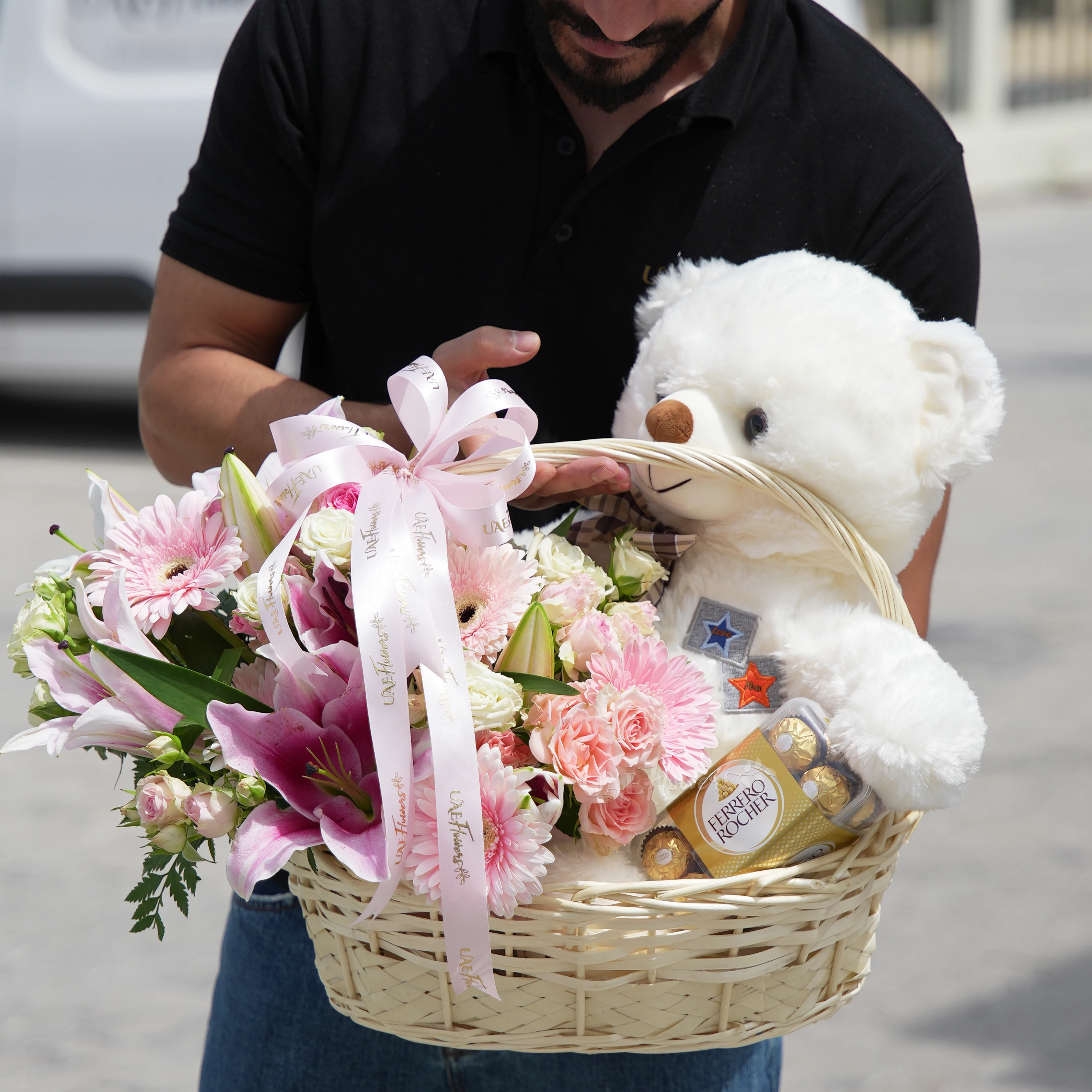 basket arrangement with 5 pink gerberas, 2 pink lilies, 4 pink and white spray roses,