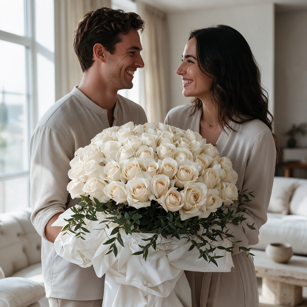 A bouquet of 40 white roses with greens in white and black wrapping paper tied with a white ribbon