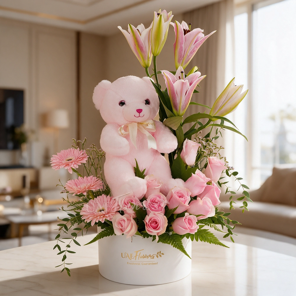 pink lily, pink gerberas, and pink roses in a round white box with a small pink teddy bear