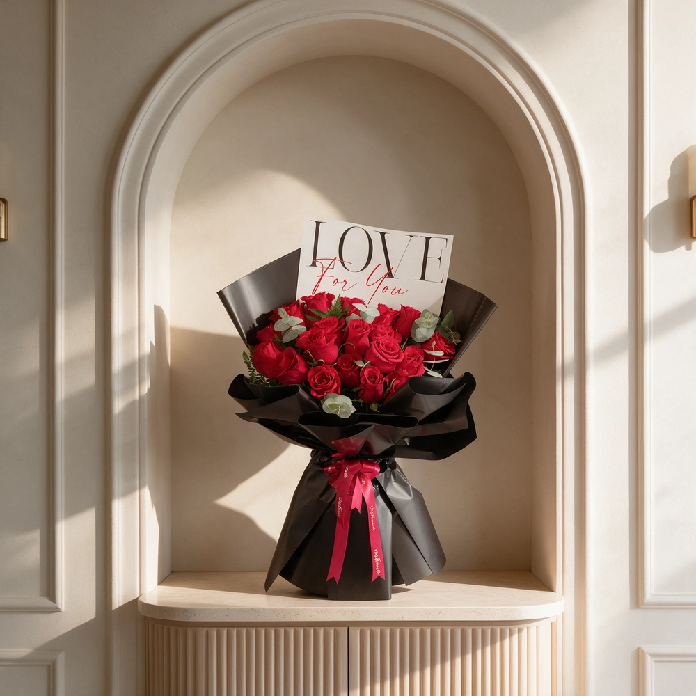 20 red roses with green fillers, wrapped in black and tied with red ribbons.